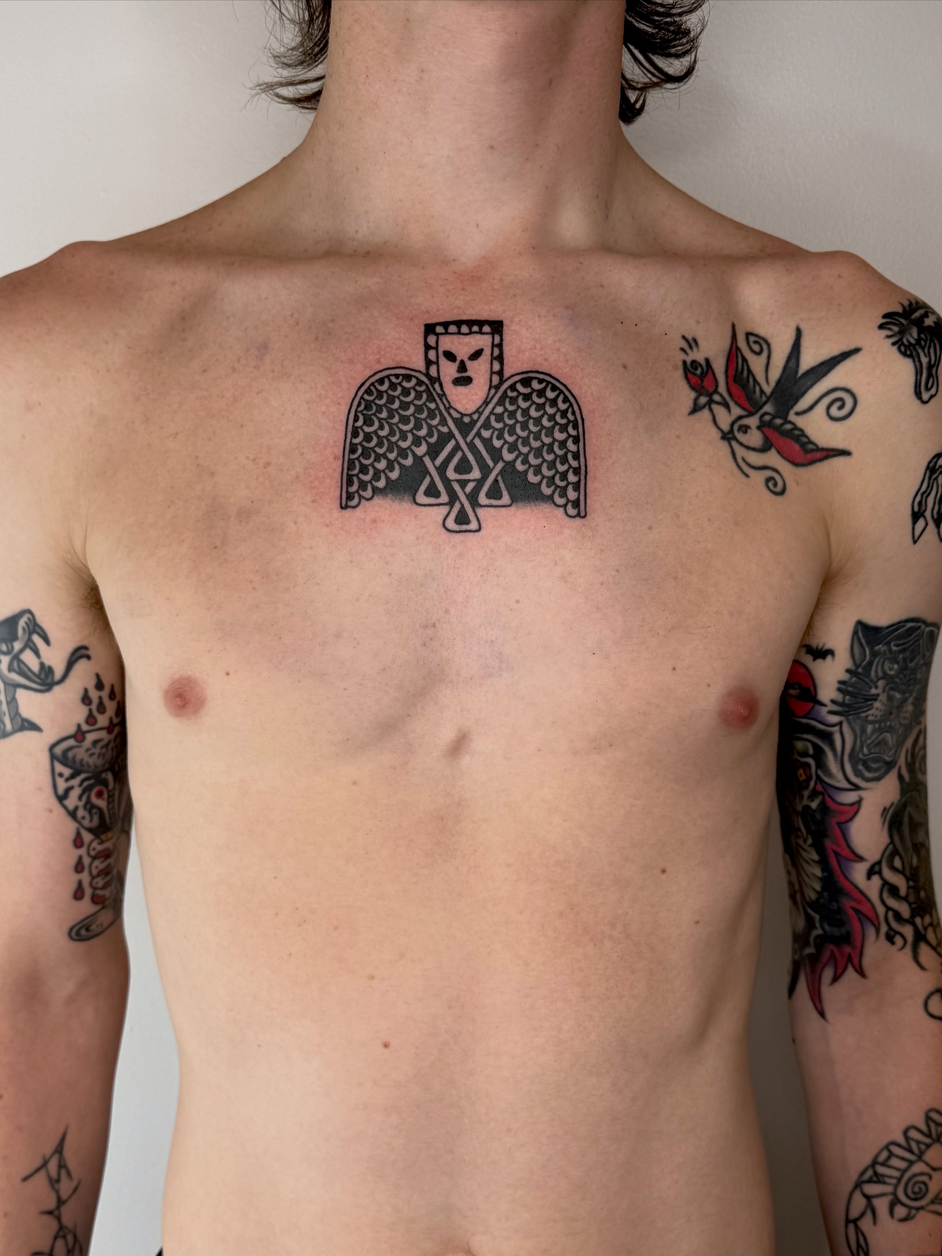 Winged figure American traditional tattoo on the chest by Roman