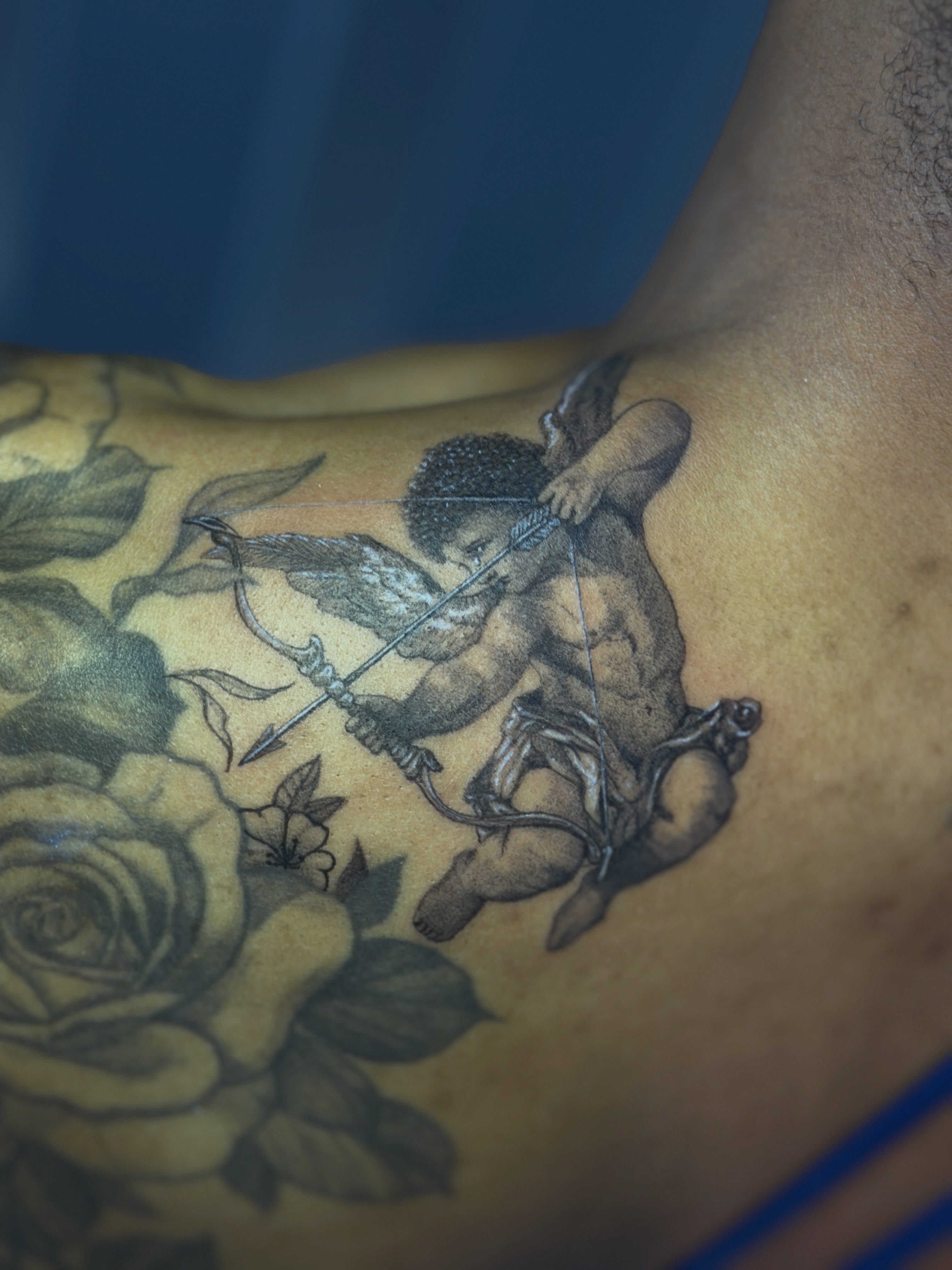 Cherub with bow and arrow black and grey tattoo on the chest by Raciel Fabian Romero