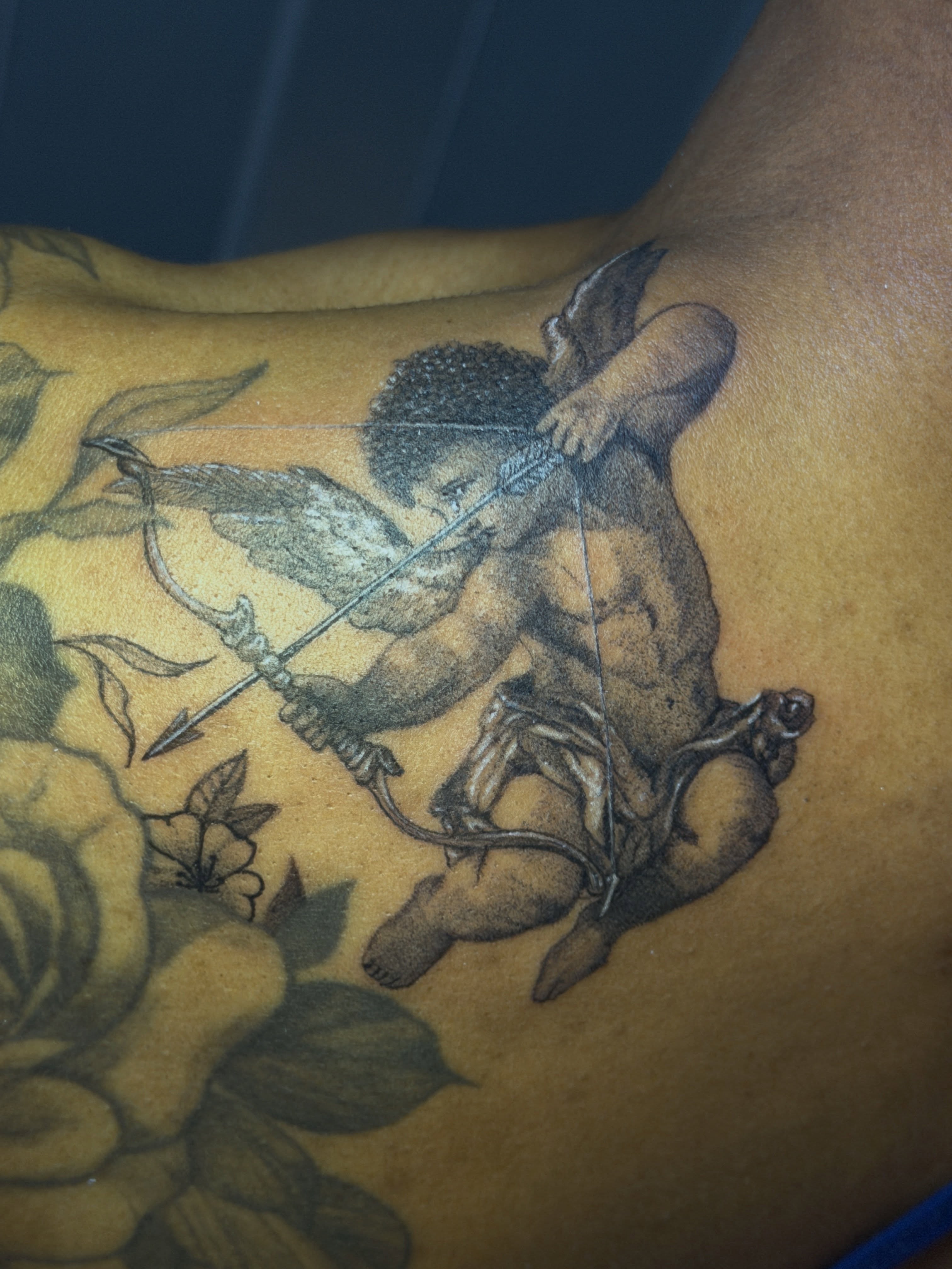 Cherub with bow neo-traditional tattoo on the chest by Raciel Fabian Romero