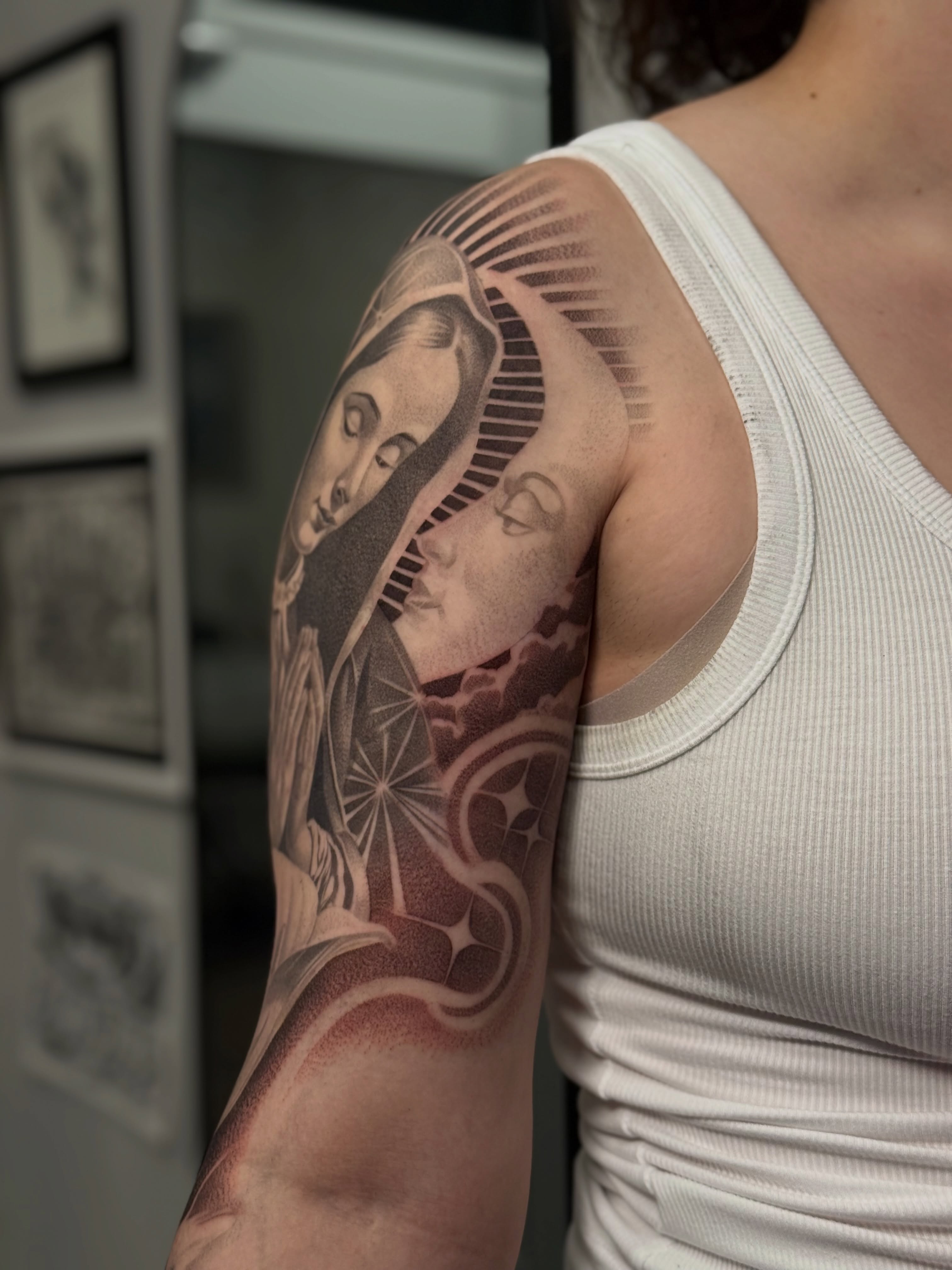 Religious figures realism tattoo on the upper arm by Vanessa Valdivia