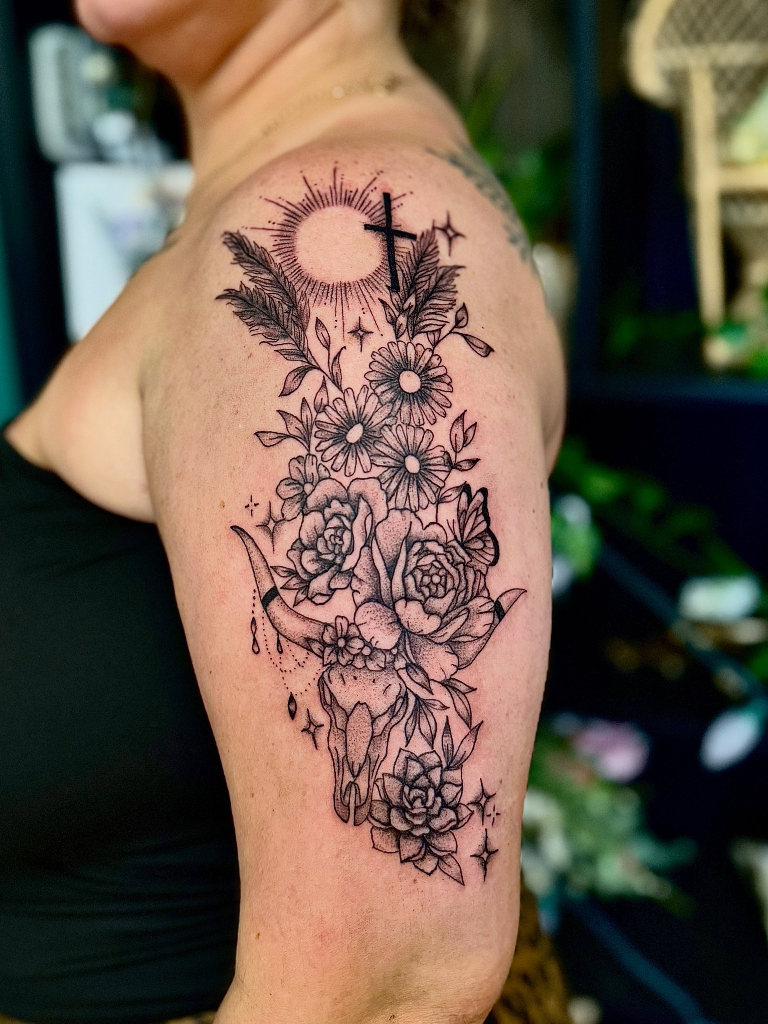 Cow skull with flowers ornamental tattoo on the shoulder by Haley Bates