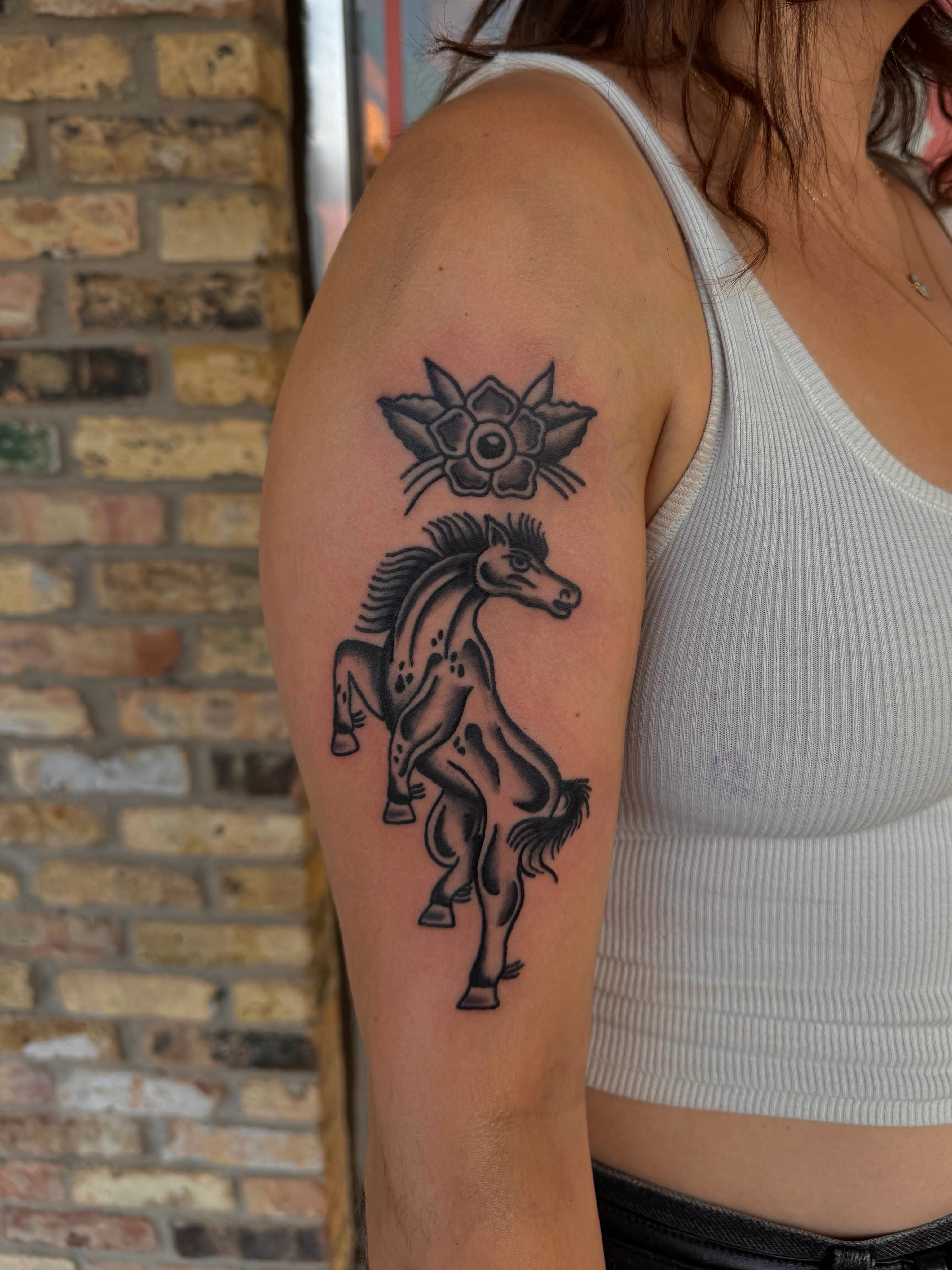 Galloping horse black and grey tattoo on the upper arm by Myka King