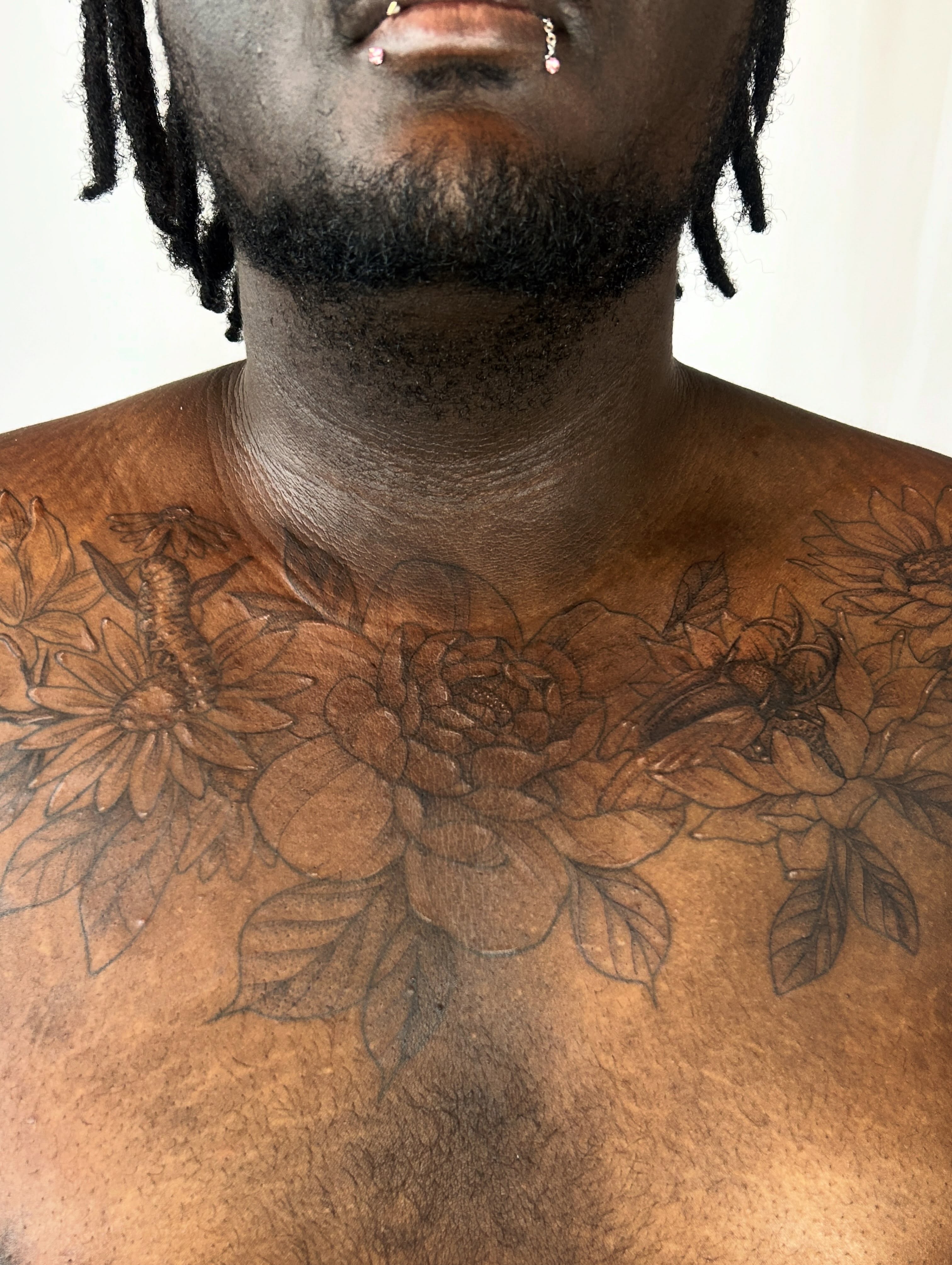 Floral arrangement black and grey tattoo on the chest by Nikki Power