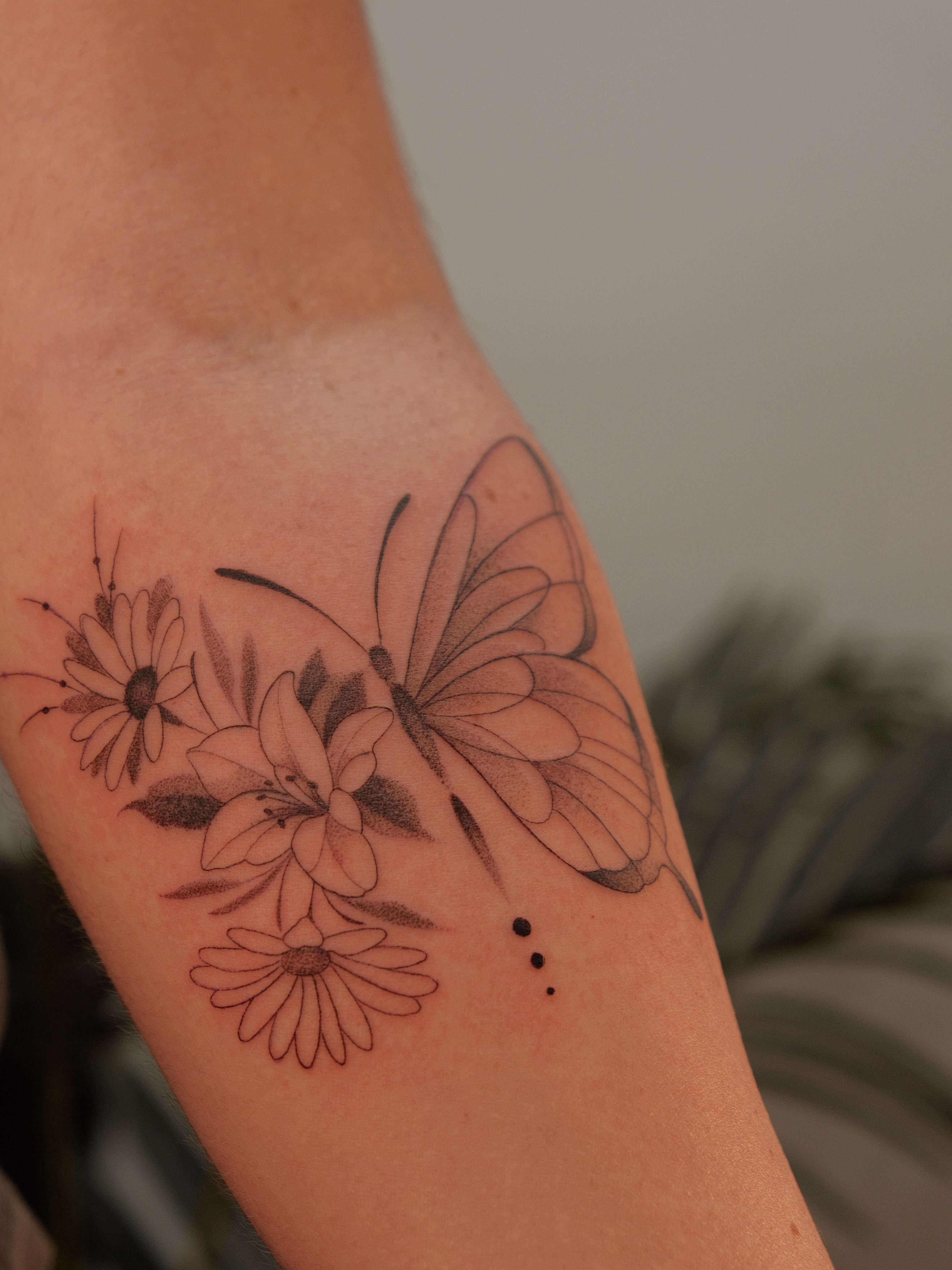 Butterfly and flowers realism tattoo on the forearm by JoeyJazz
