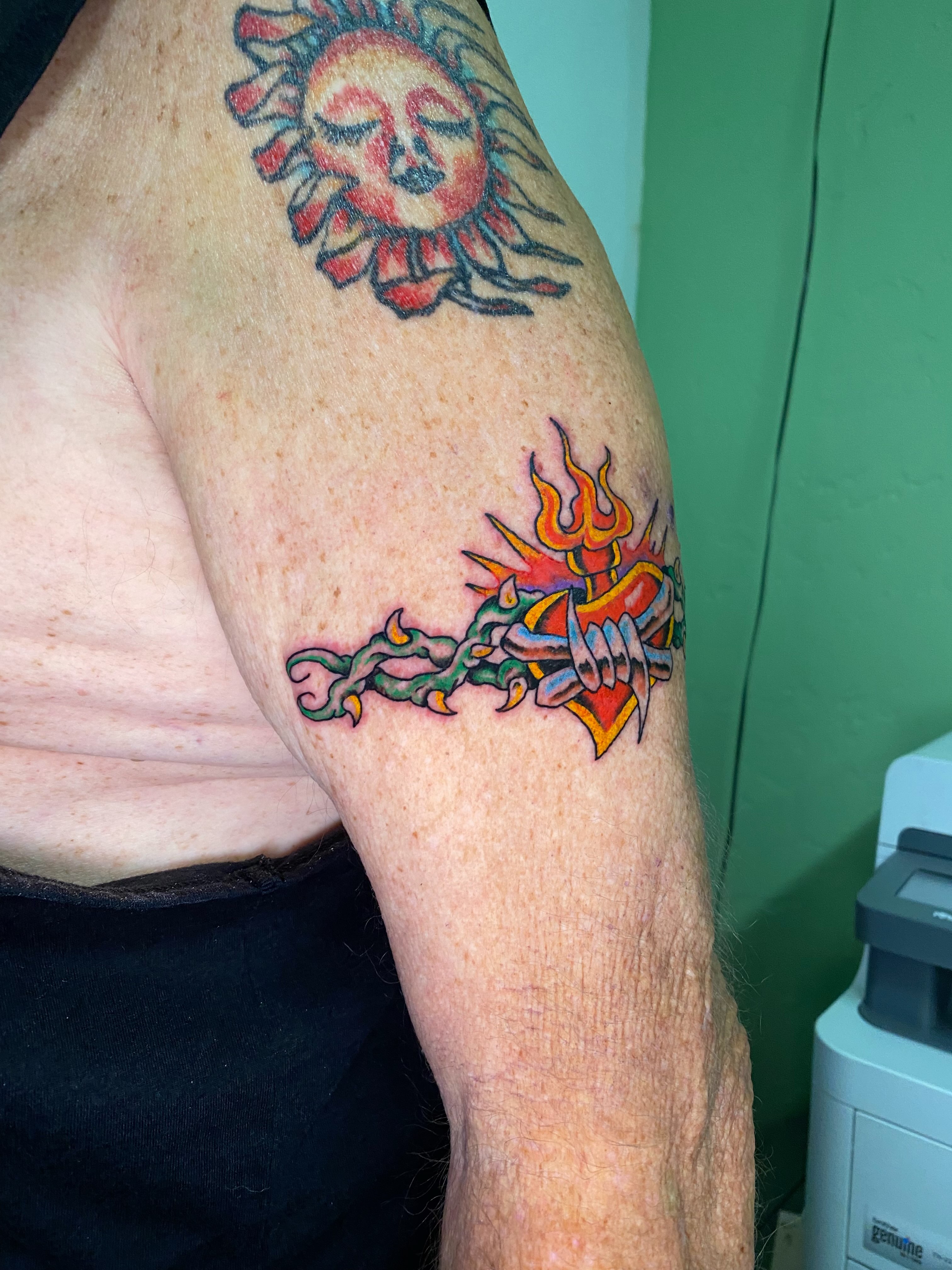 Flame and heart American traditional tattoo on the forearm by Hayden Earley