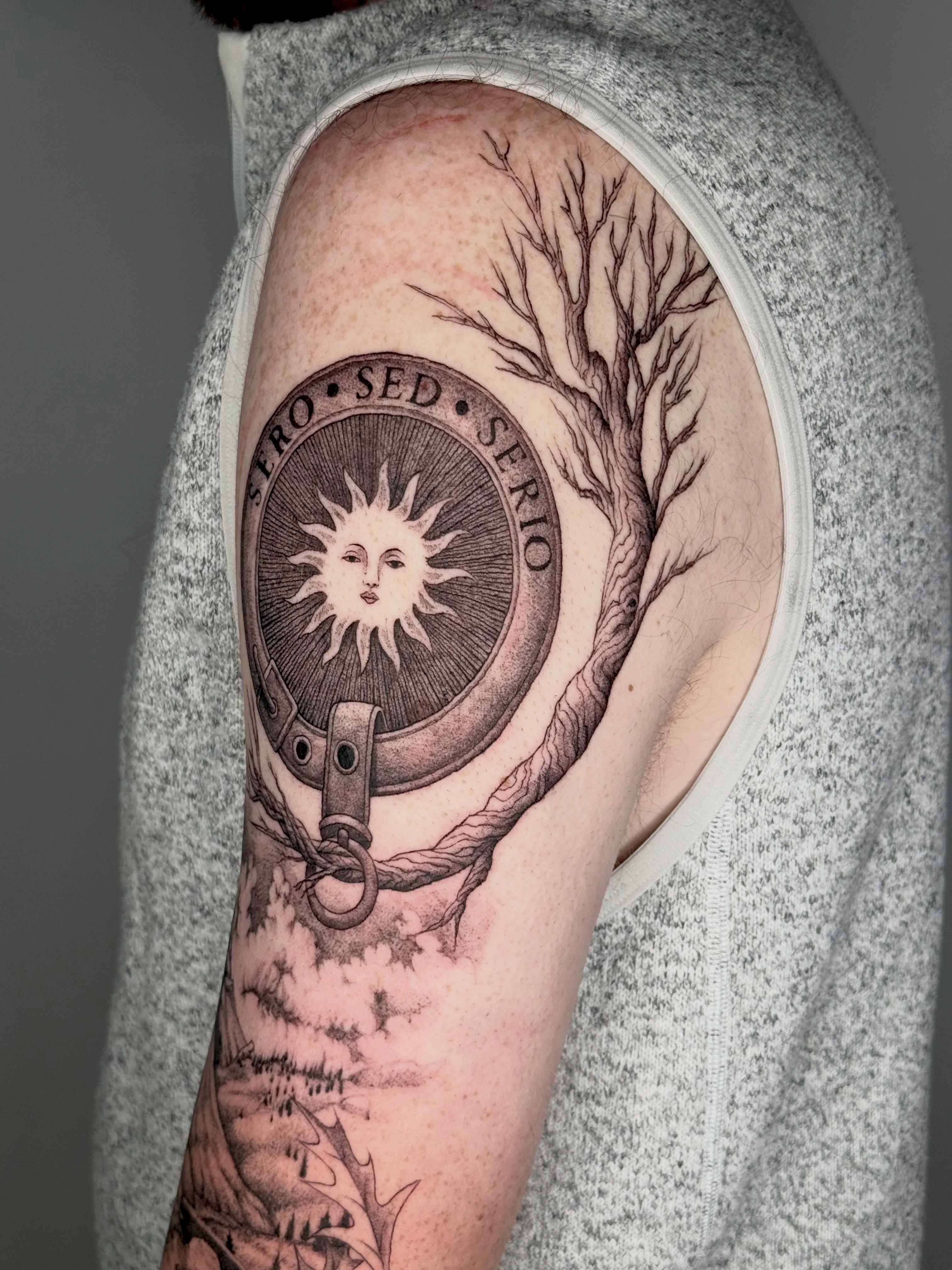 Mirror with sun realism tattoo on the upper arm by Andrew Flatts