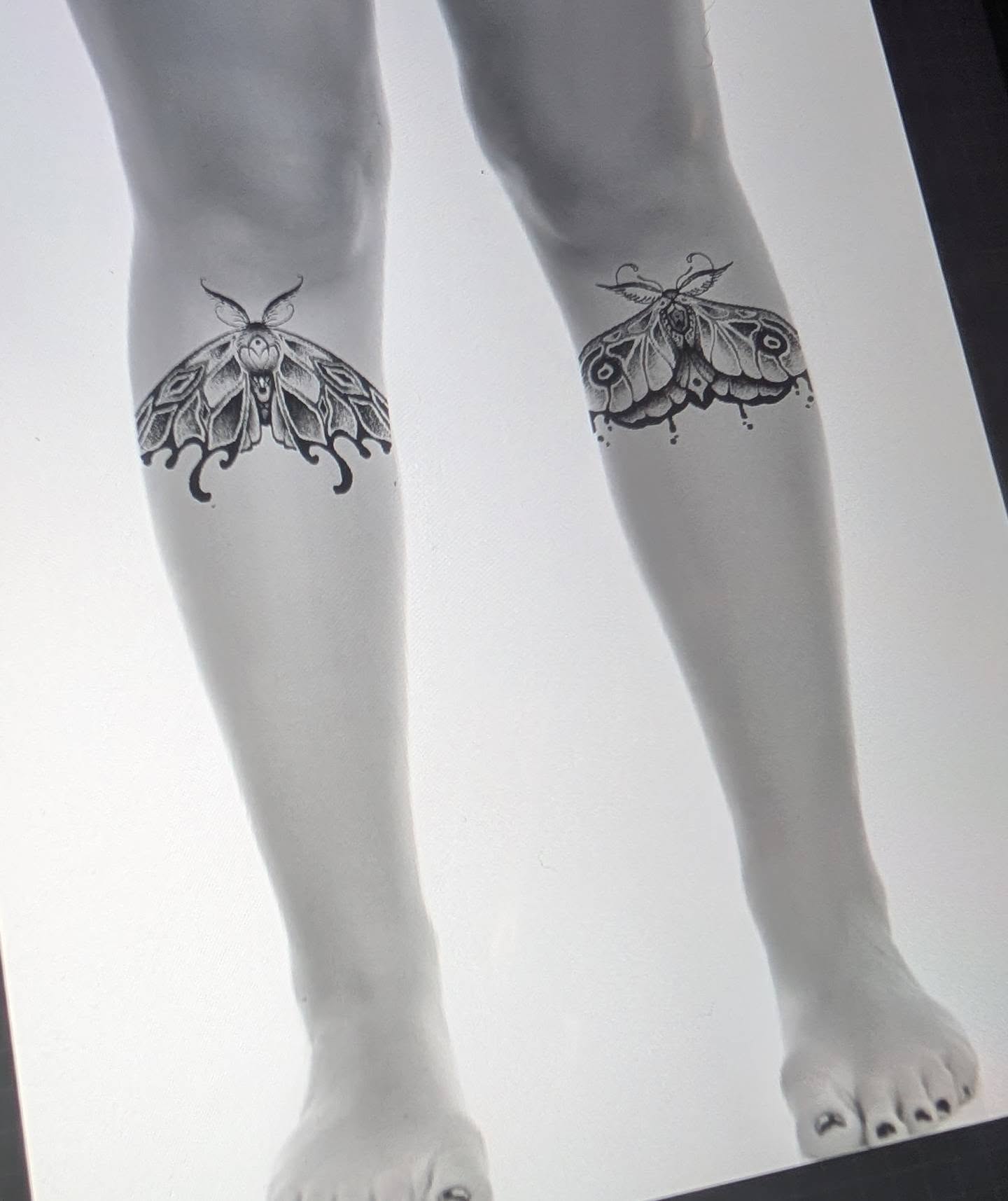 Moths black and grey tattoo on the calf by Michaela May