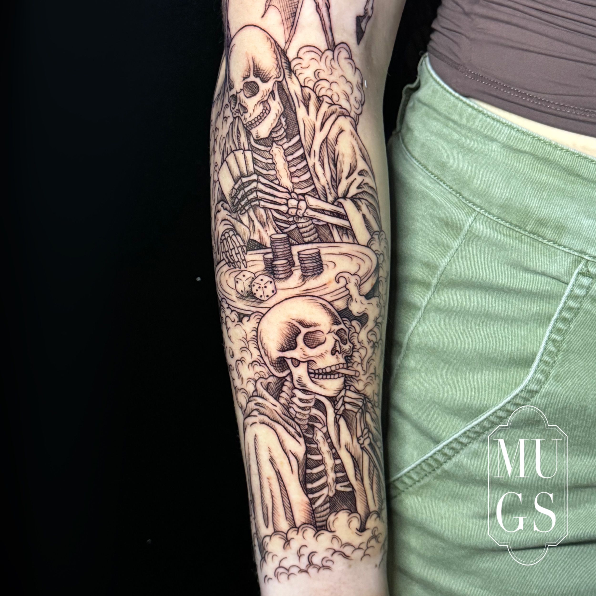 Skeletons playing dice realism tattoo on the forearm by Emily Andreozzi