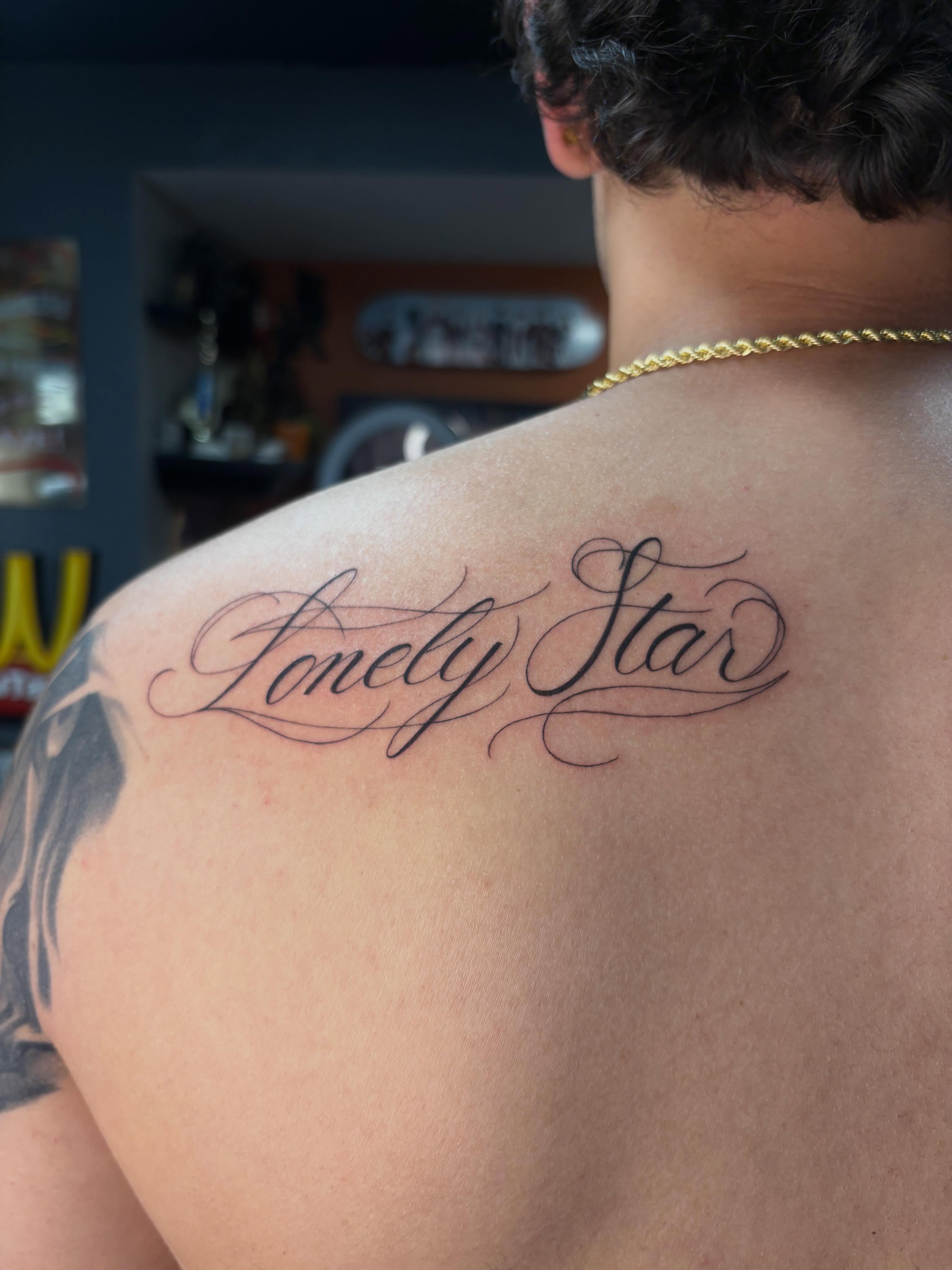 Lonely Star lettering script tattoo on the shoulder by alana khounmeuang