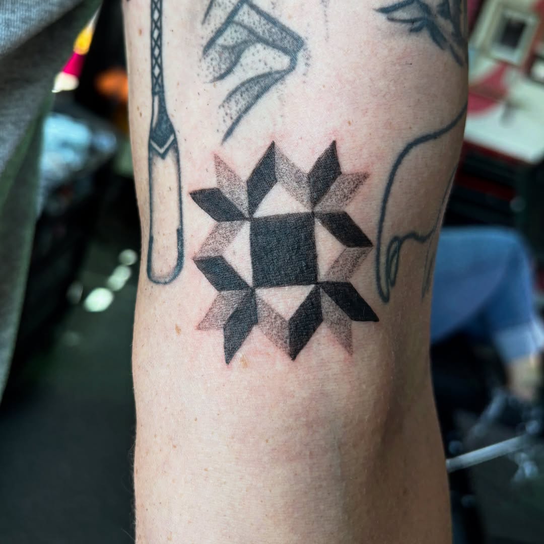 Geometric star dotwork tattoo on the forearm by Hiro Robinson