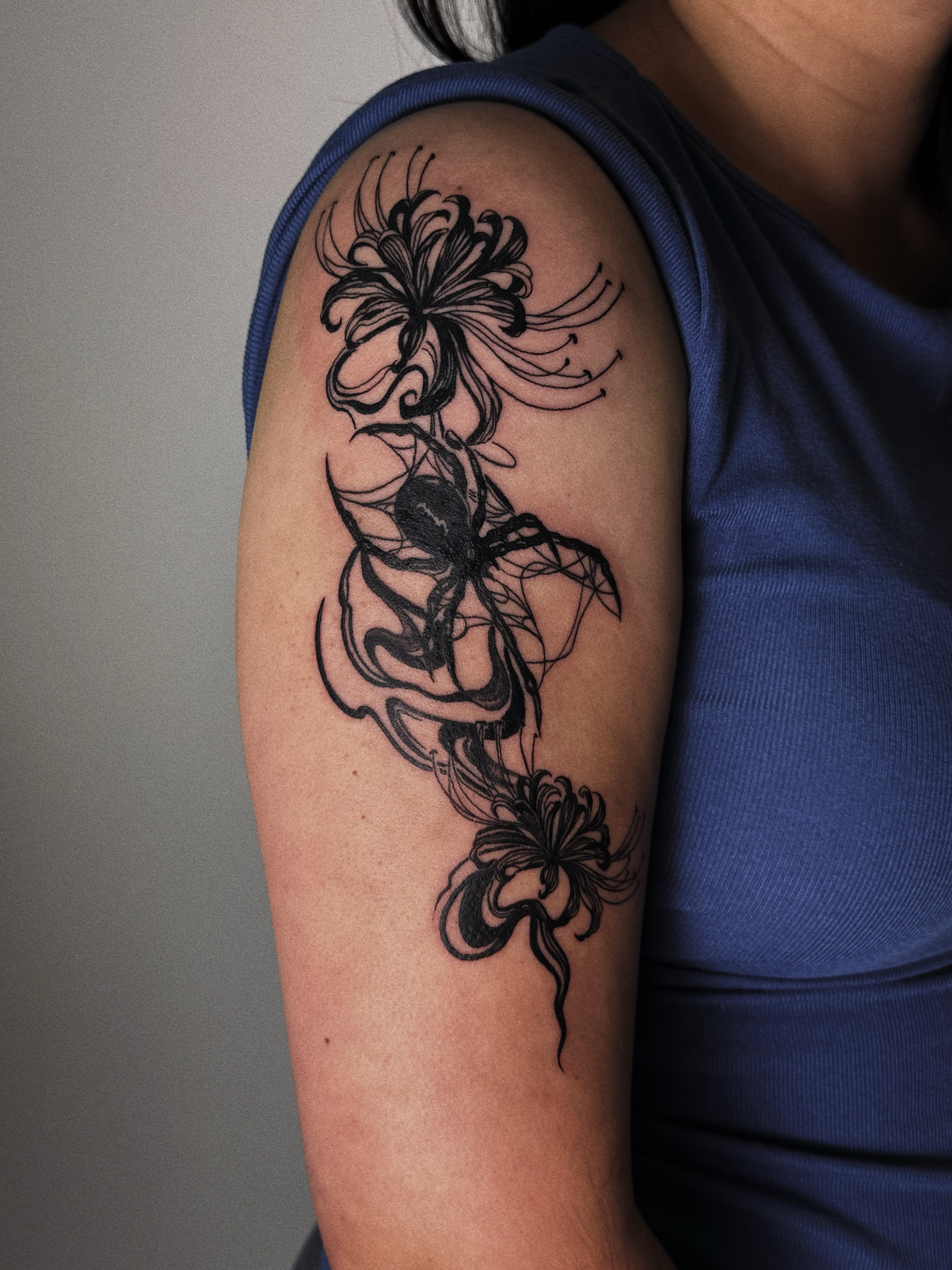 Chrysanthemum black and grey tattoo on the upper arm by Paulina Vazquez