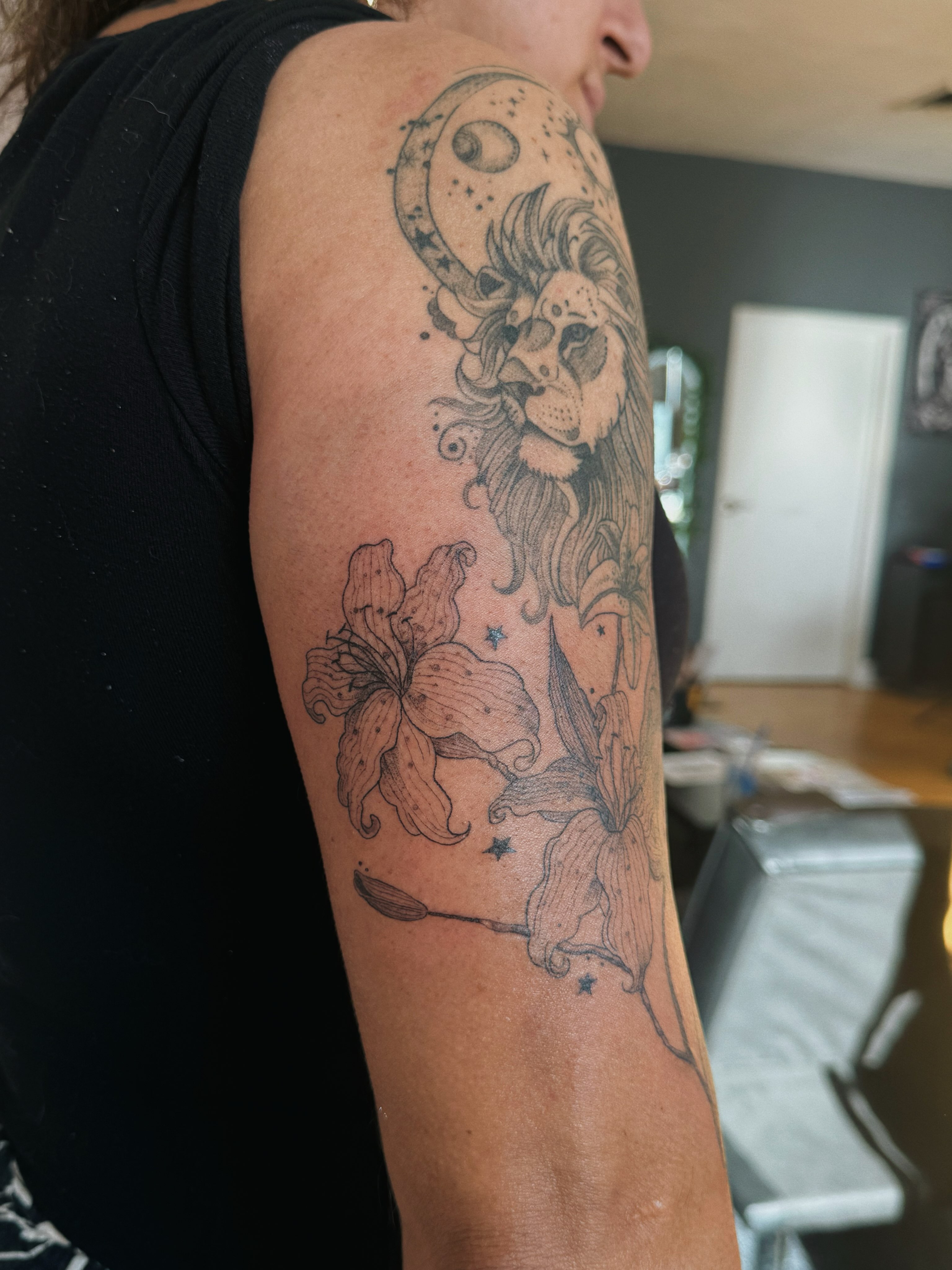 Lion and lilies realism tattoo on the forearm by Paulina Vazquez