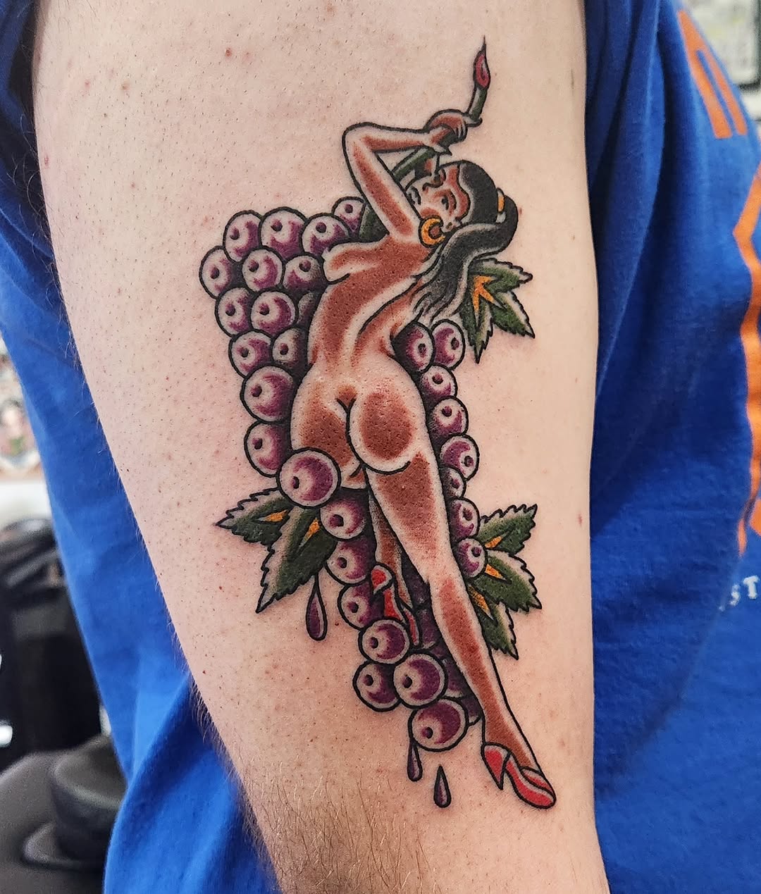 Pin-up girl with grapes neo-traditional tattoo on the forearm by Douglas Grady