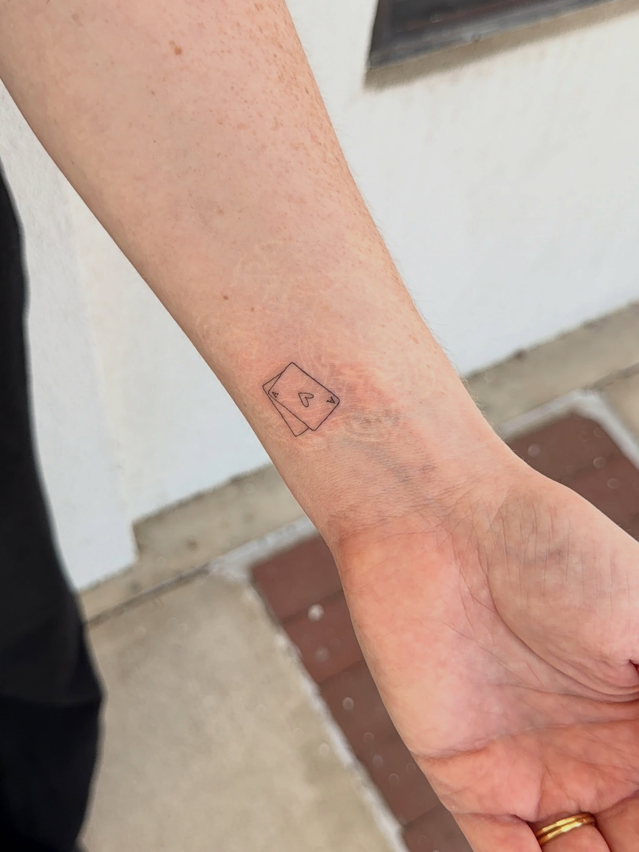 Playing card black and grey tattoo on the forearm by Jacksyn, Plano, Texas
