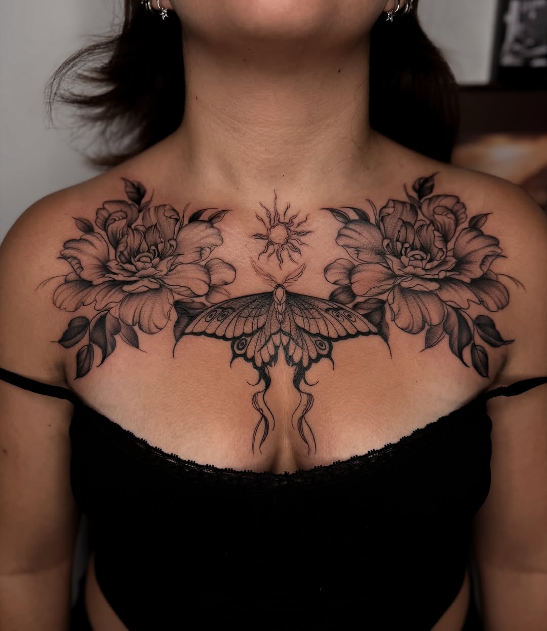Butterfly and flowers black and grey tattoo on the chest by Priscila, Los Angeles, California
