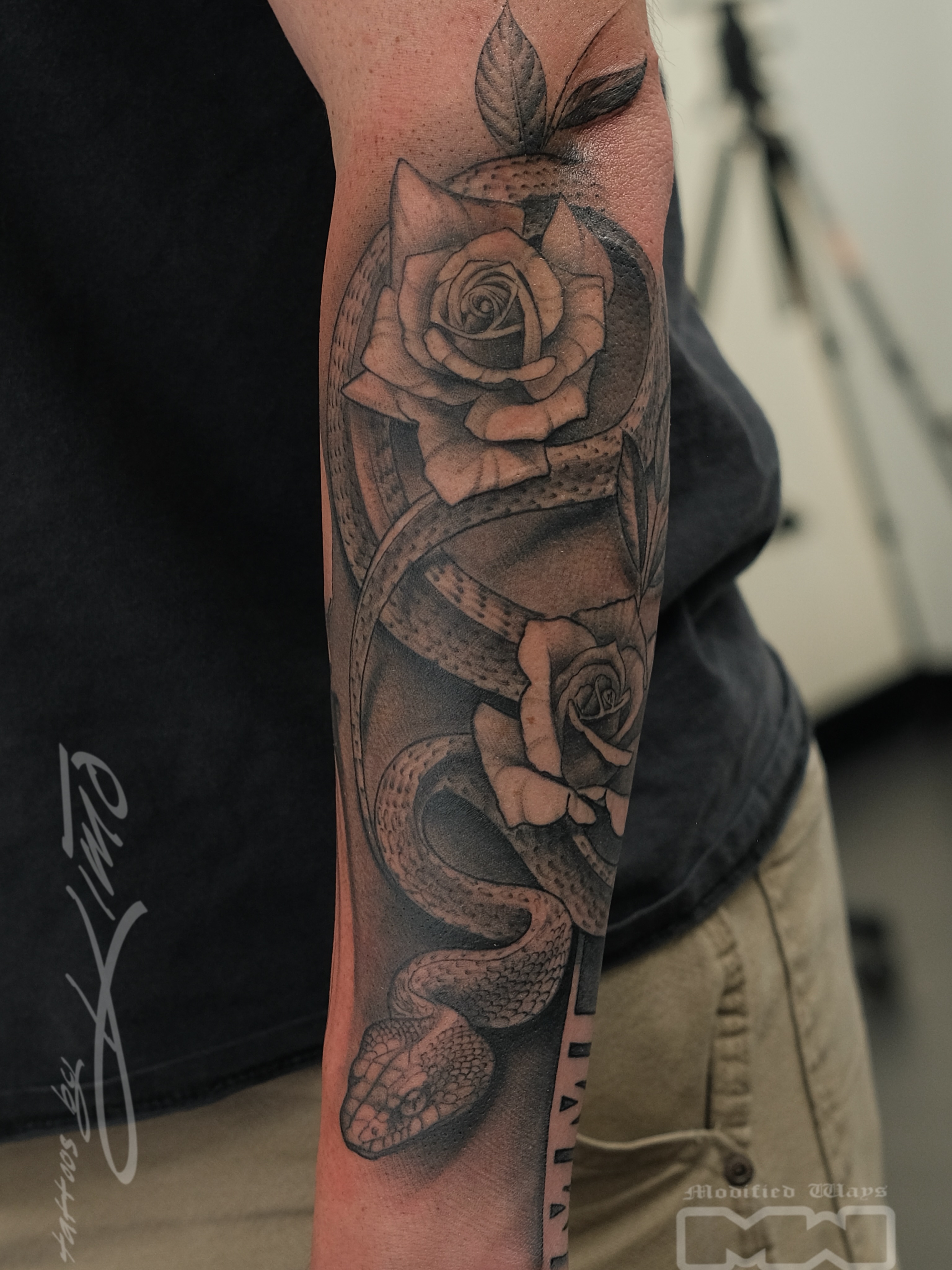 Snake and roses realism tattoo on the forearm by Kansas City tattoo artist