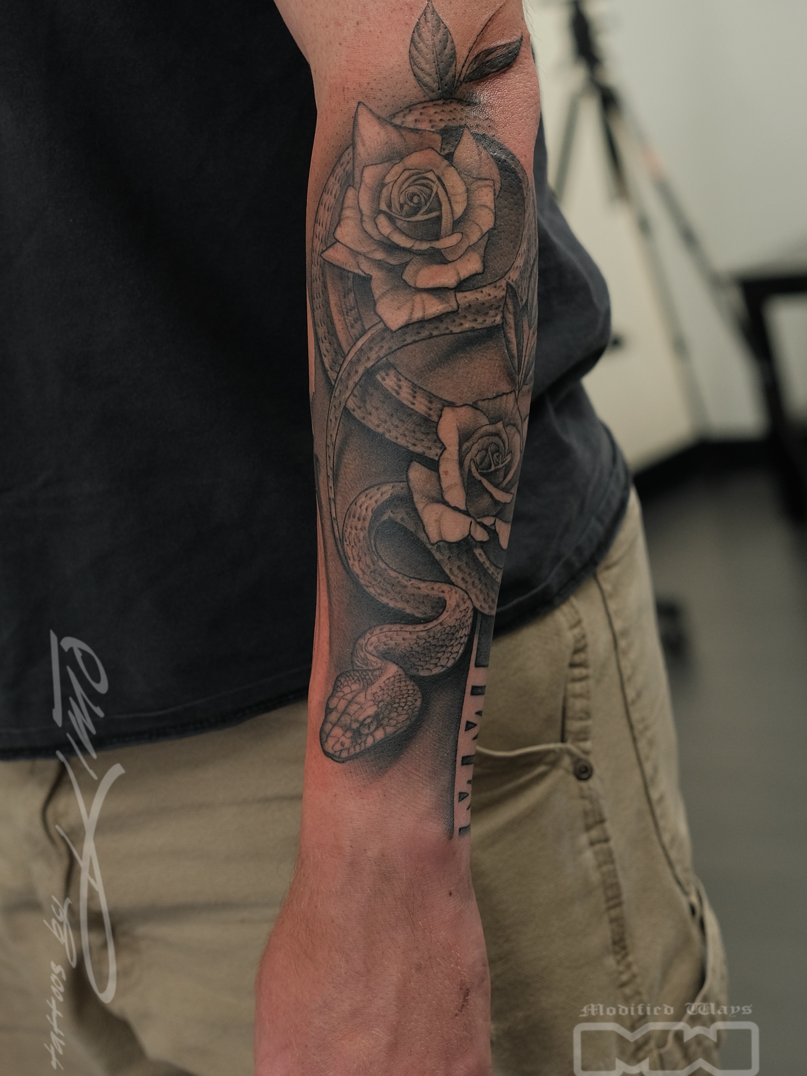 Snake and rose realism tattoo on the forearm by Kansas City tattoo artist