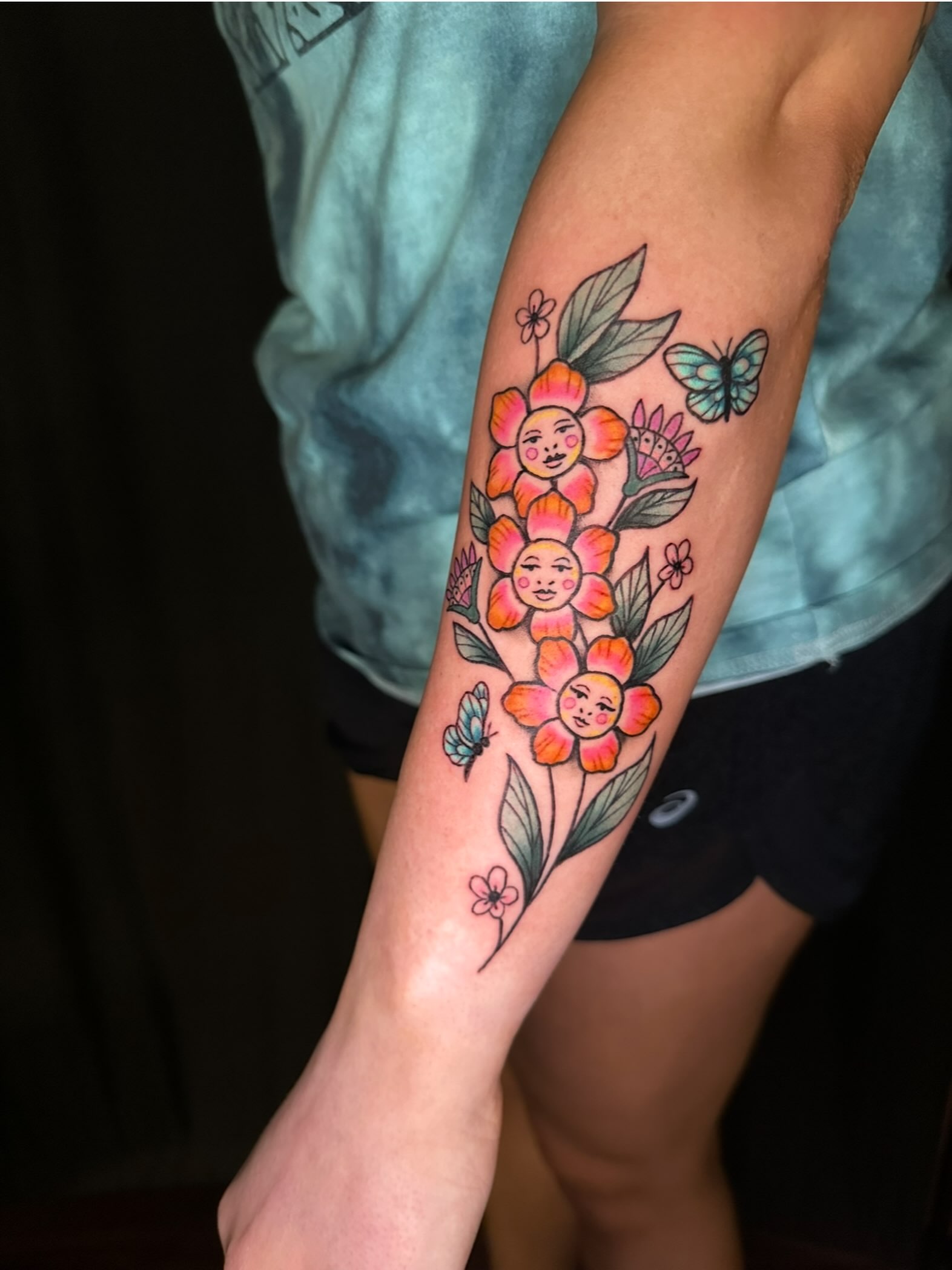 Flowers with faces new school tattoo on the forearm by Lindsey Bendsey