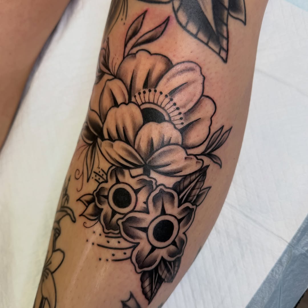 Floral skull American traditional tattoo on the forearm by Amy Kolton