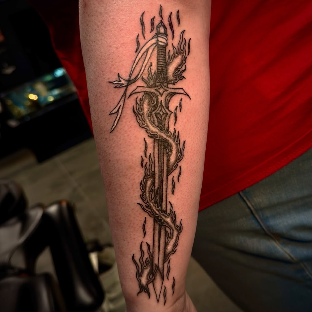 Flame and sword black and grey tattoo on the forearm by Seth Christianson