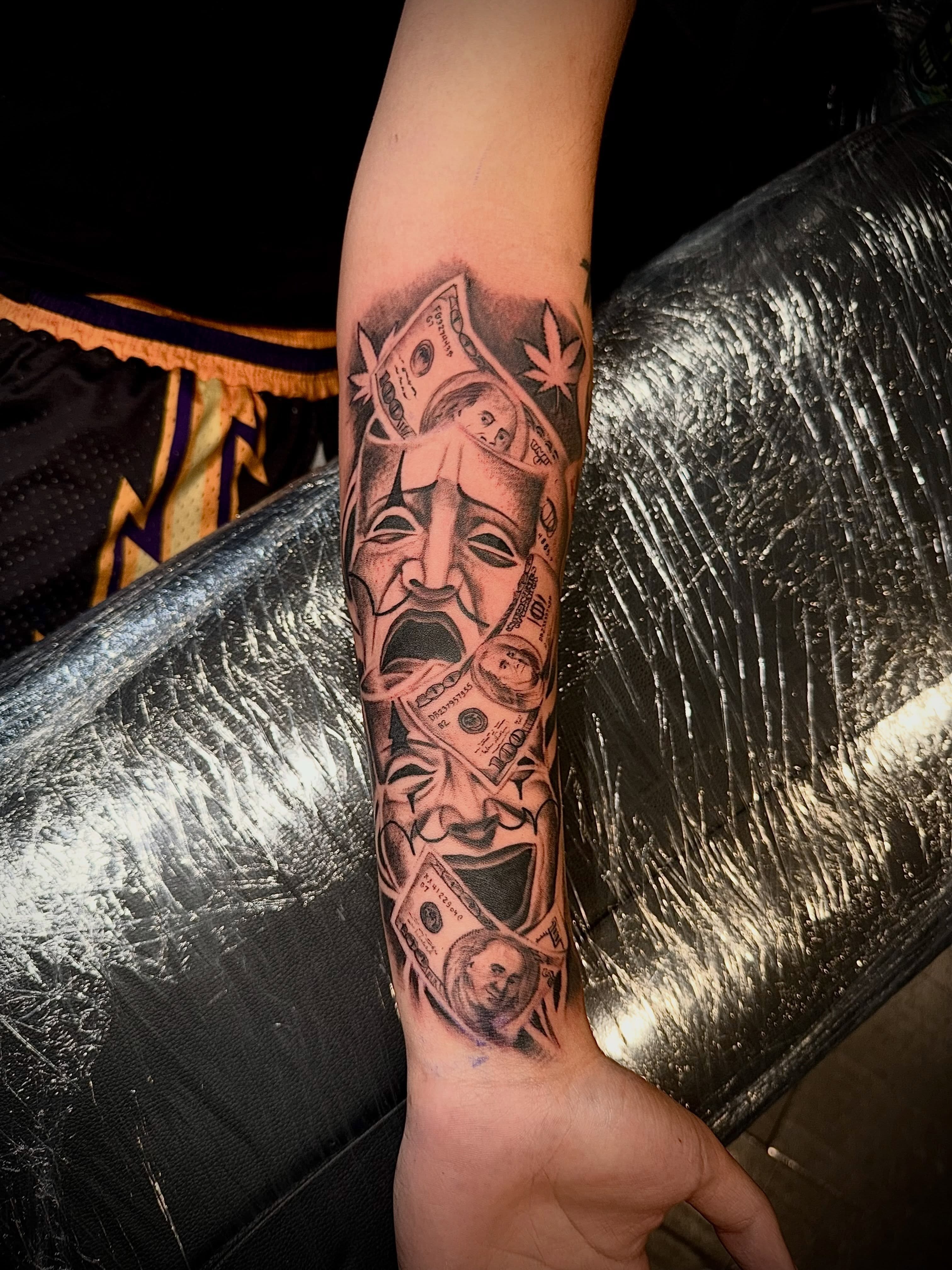 Dollar bills and masks geometric tattoo on the forearm by Clifford Jordan