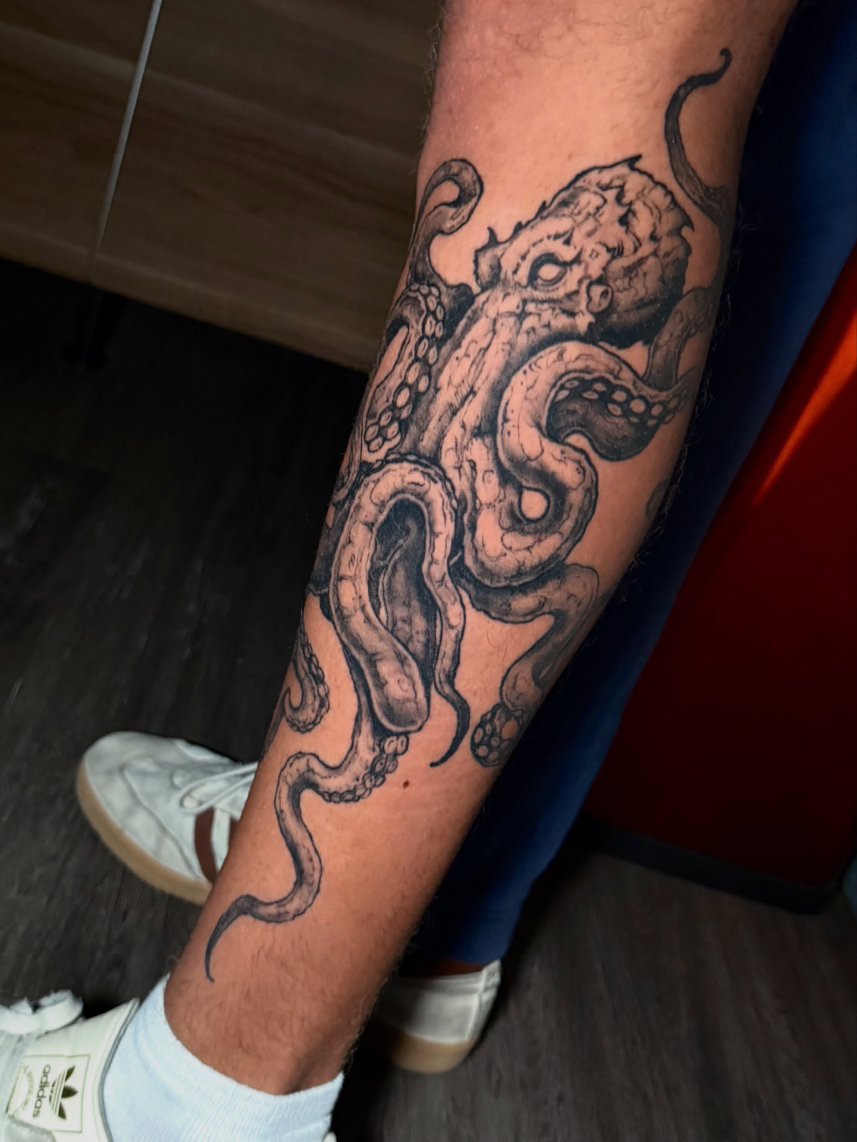 Octopus black and grey tattoo on the forearm by Adam Newton