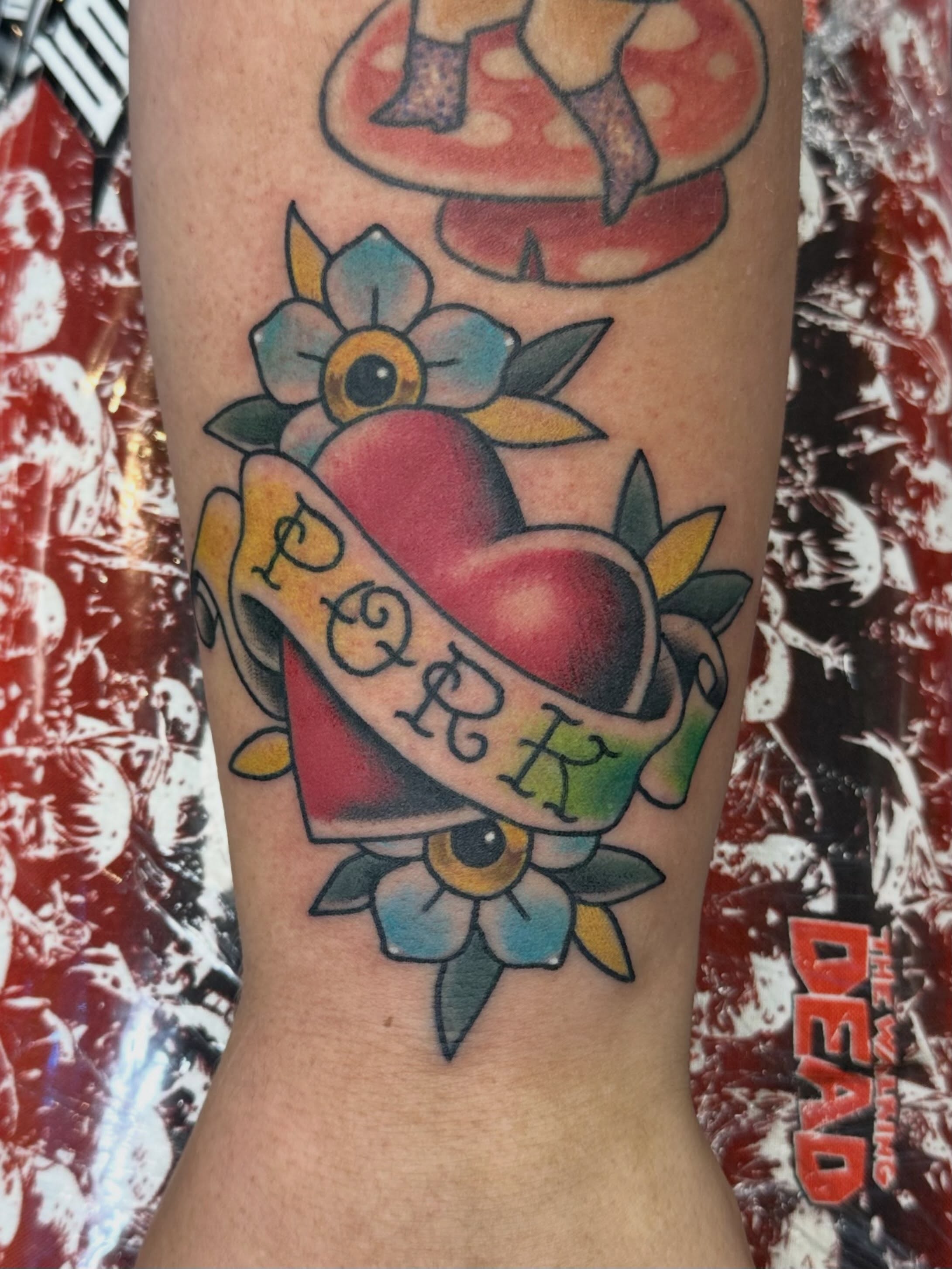 Heart with ribbon American traditional tattoo on the forearm by Dorrough Tattooer