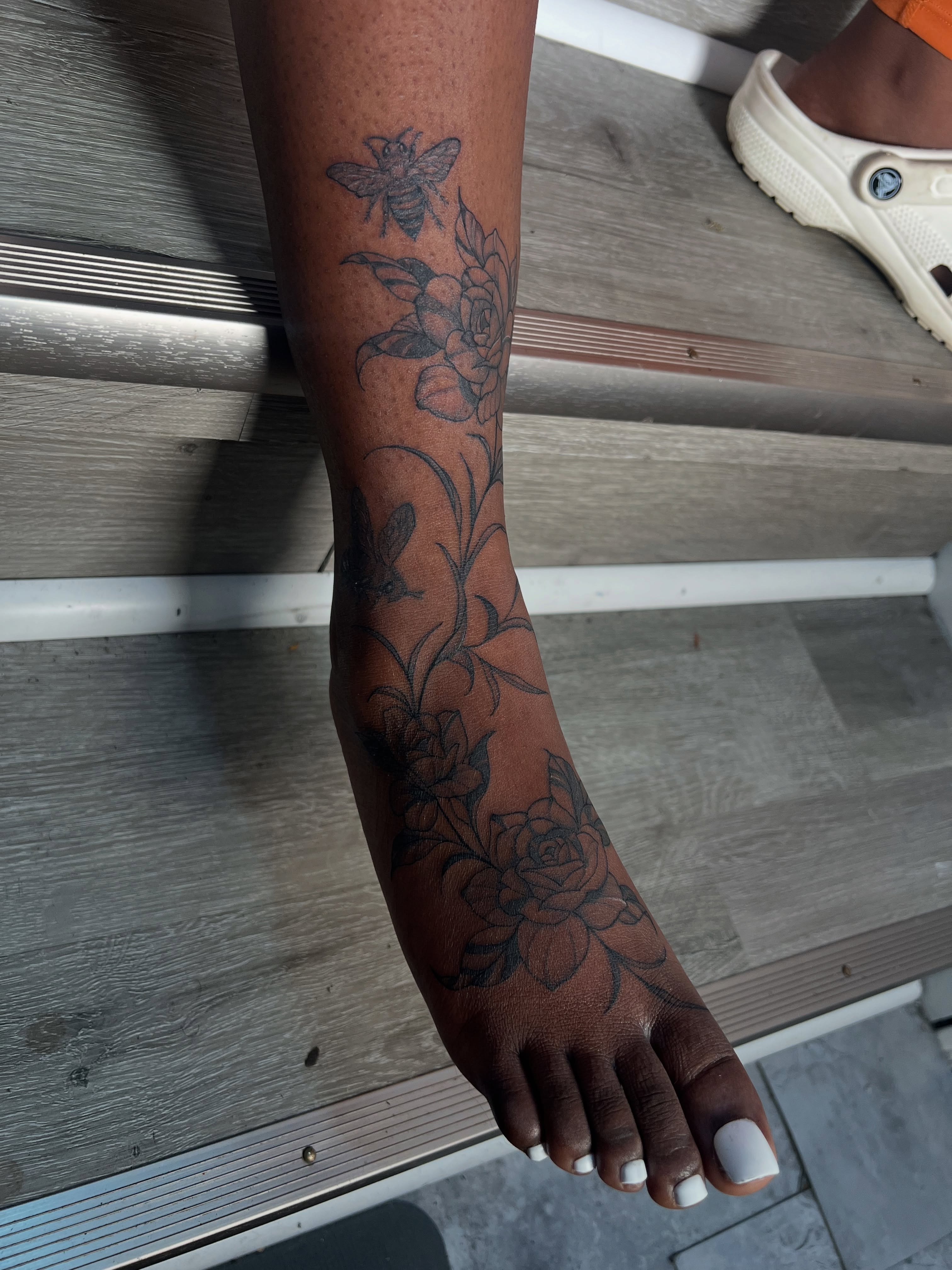 Floral and bee black and grey tattoo on the forearm by V