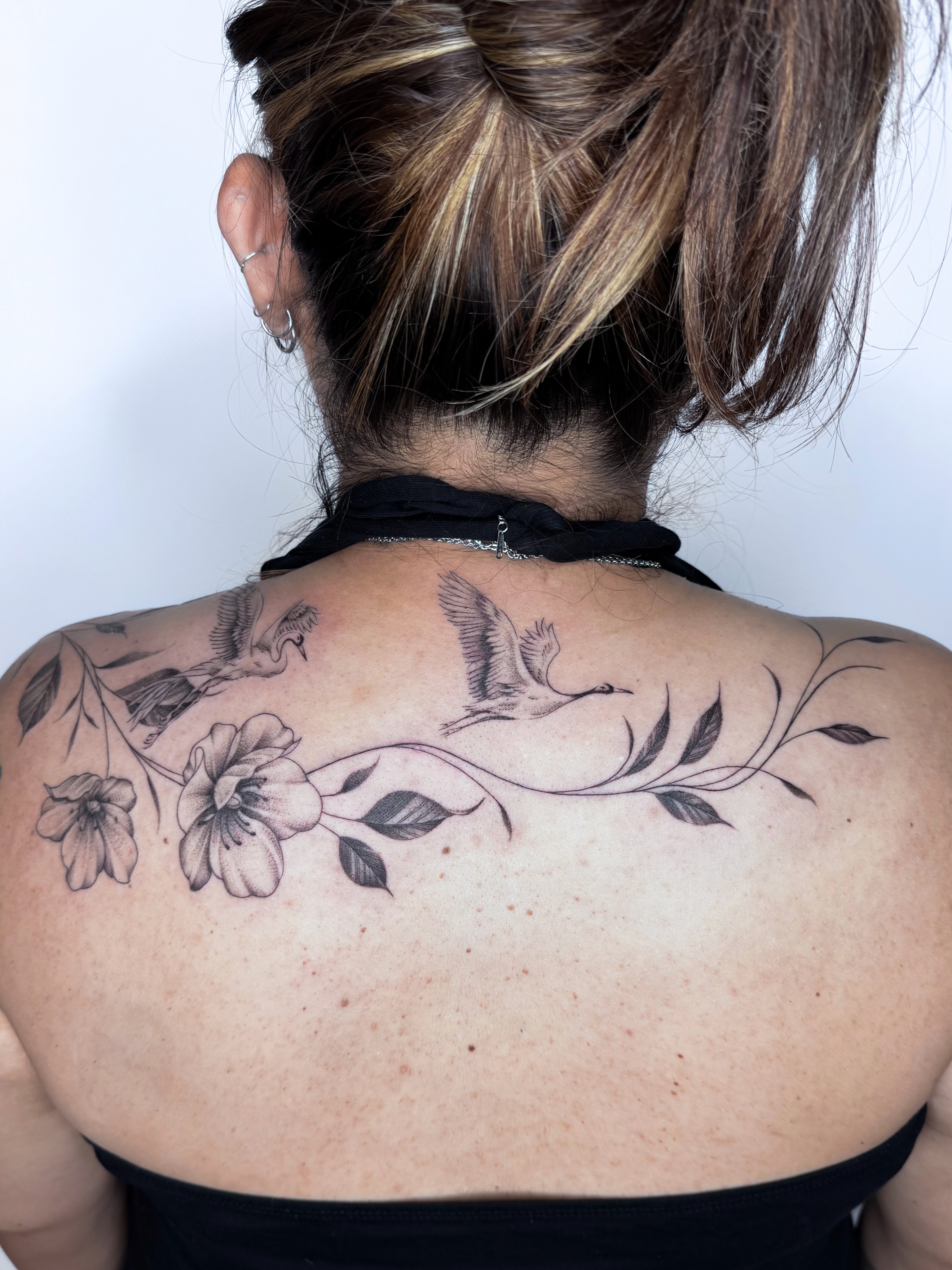 Birds and flowers black and grey tattoo on the back by @nudylicioustattoos