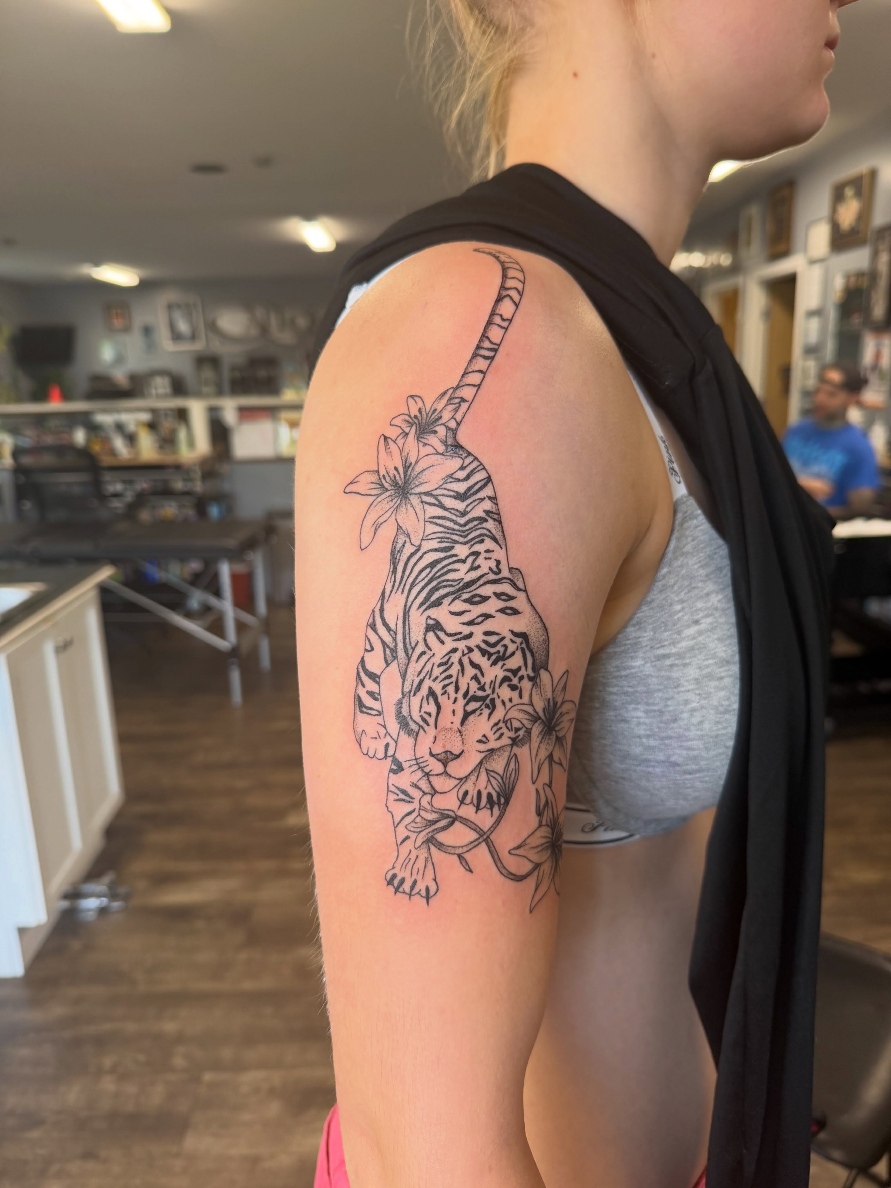 Tiger and flowers realism tattoo on the upper arm by Hope Powell, Vancouver, Washington