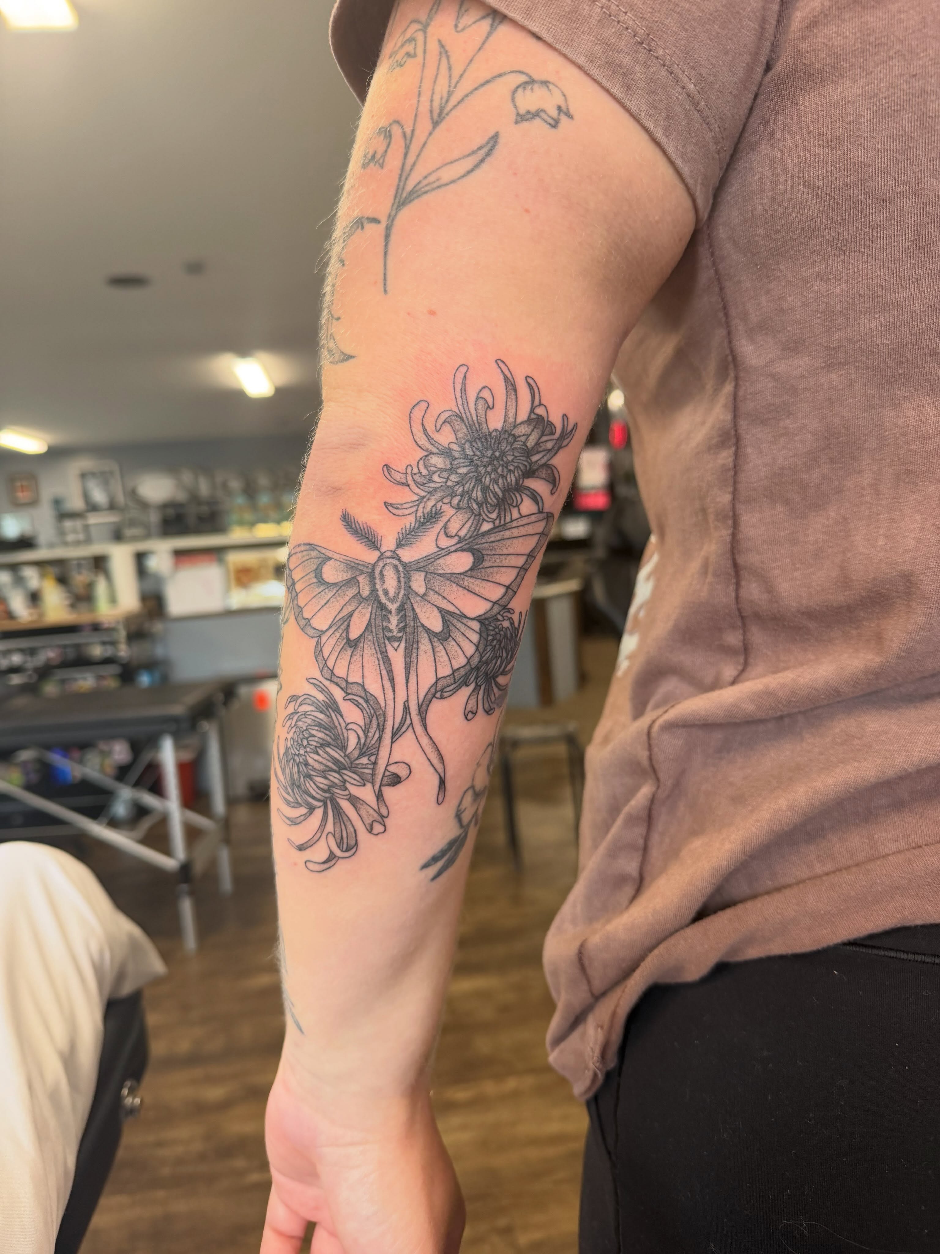 Moth and flowers black and grey tattoo on the forearm by Hope Powell, Vancouver, Washington