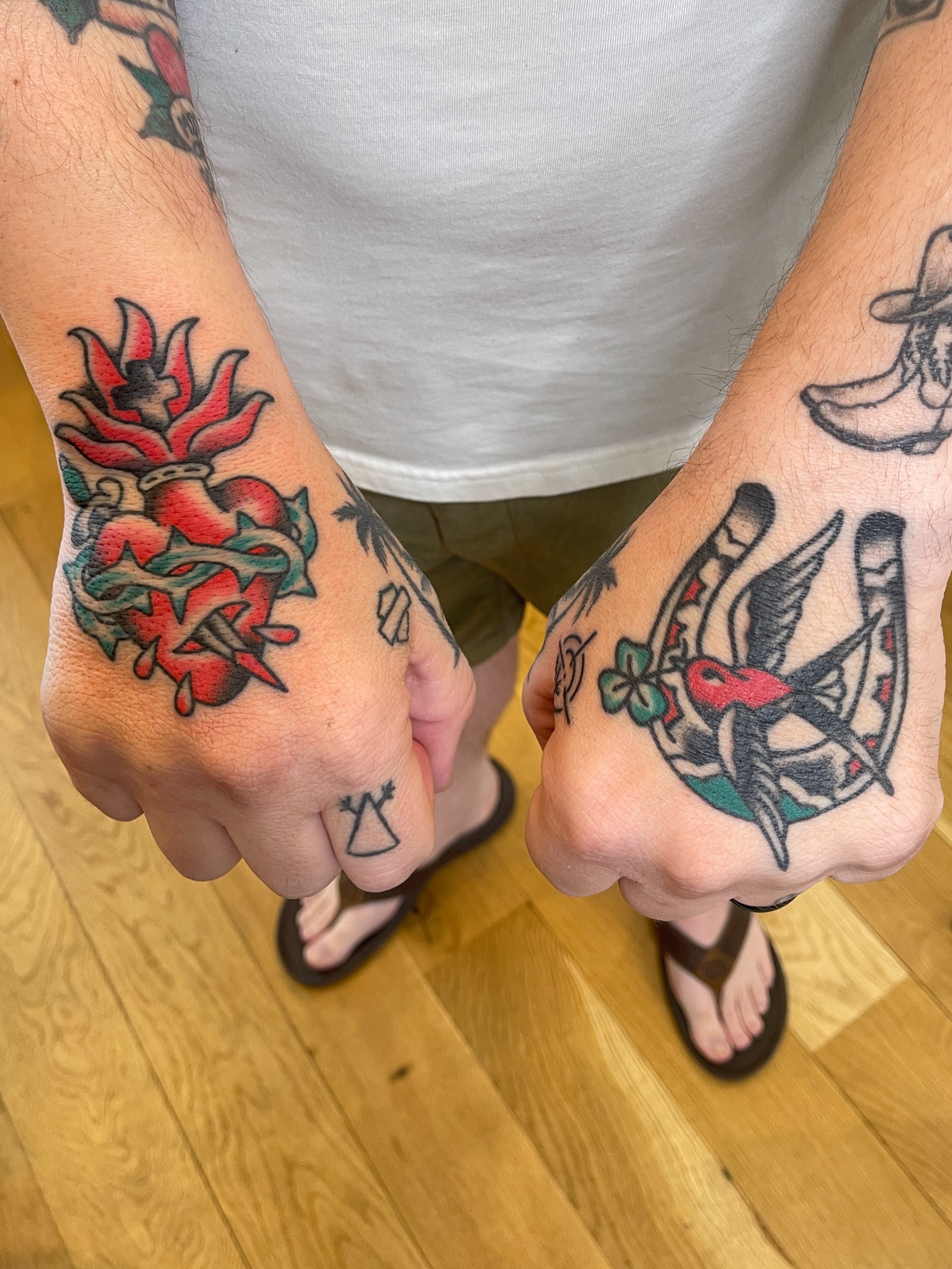 Heart and flower American traditional tattoo on the hand by Spencer Reisbeck