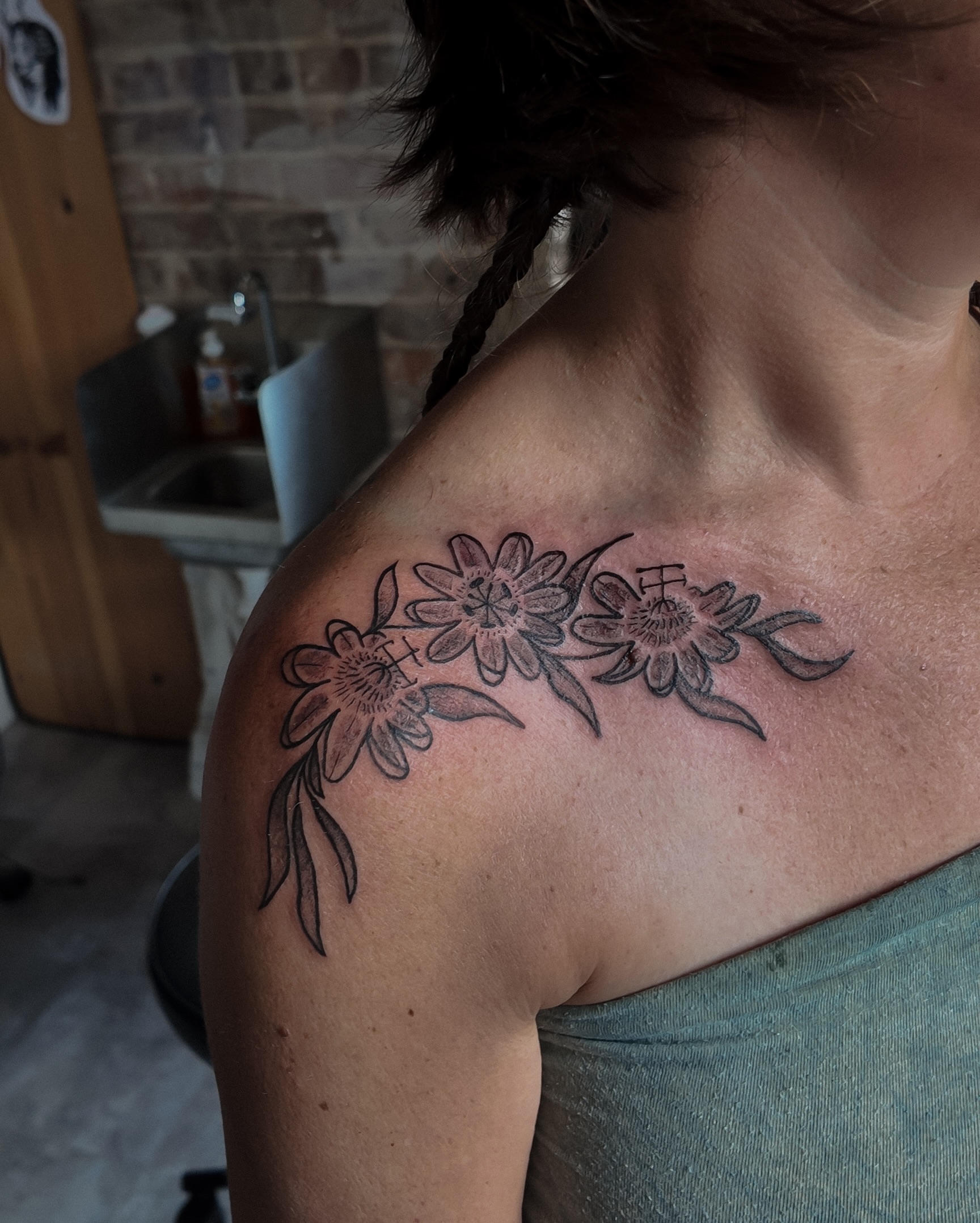 Floral arrangement black and grey tattoo on the shoulder by Morgan Diann