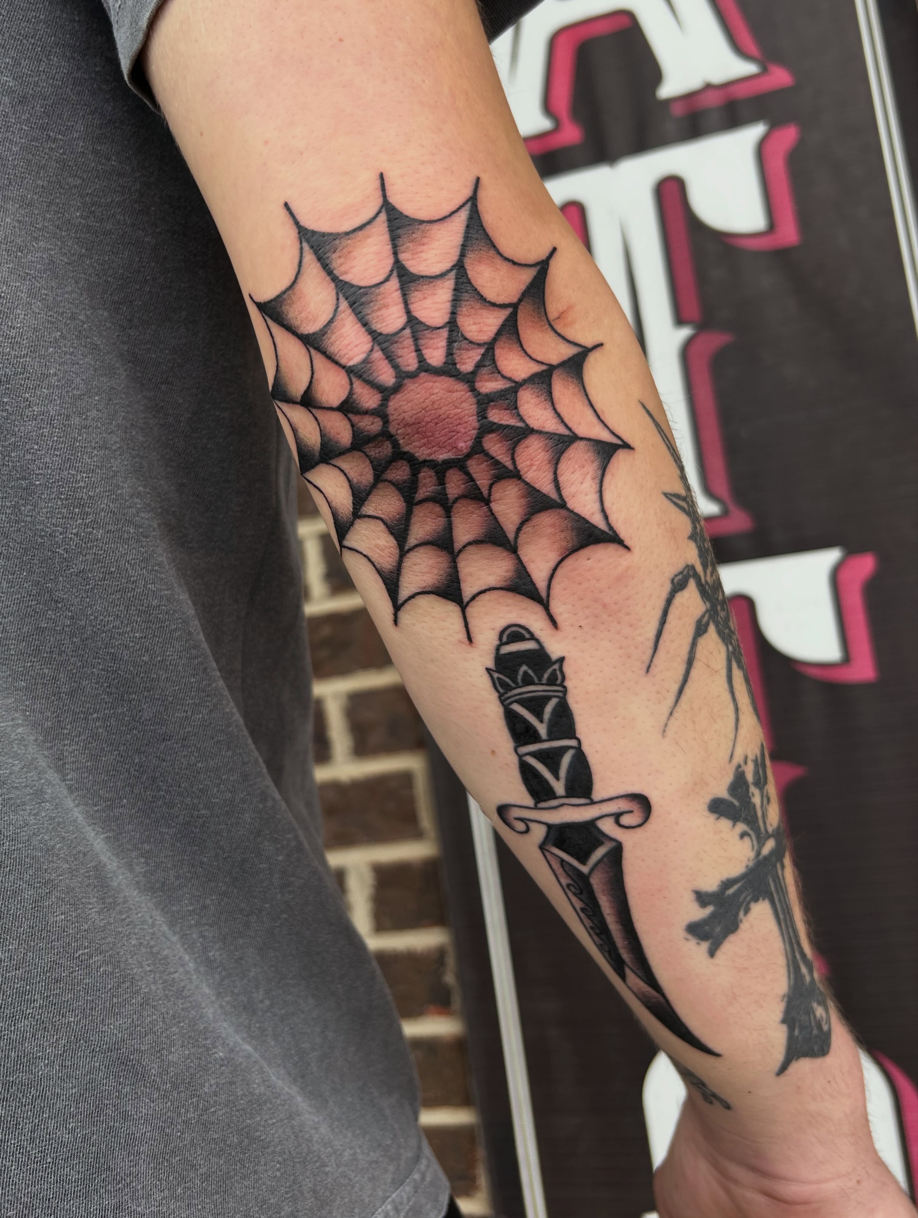 Spiderweb geometric tattoo on the forearm by Zach Andrews