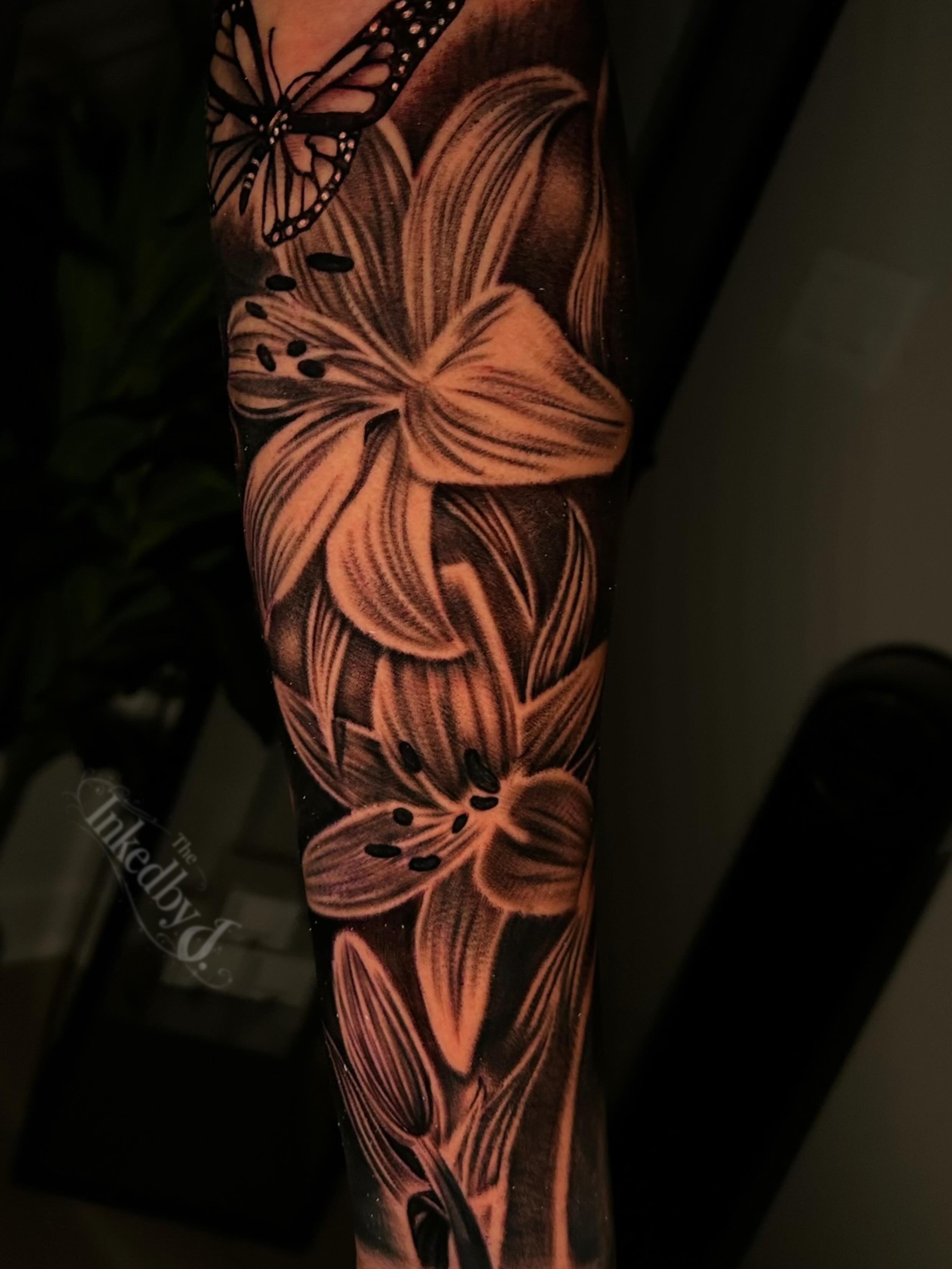 Lilies and butterfly realism tattoo on the forearm by Jaylen - Atlanta Tattoo Artist