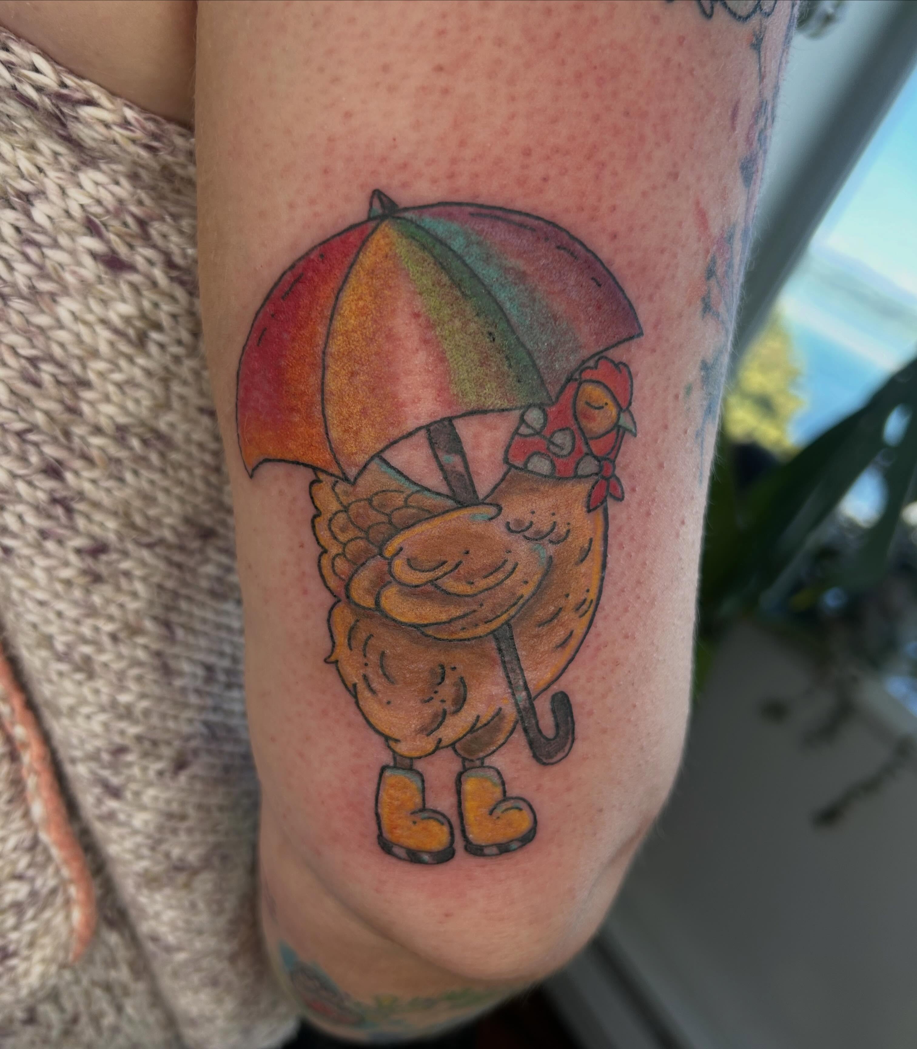 Chicken with umbrella new school tattoo on the forearm by Reilley Earles