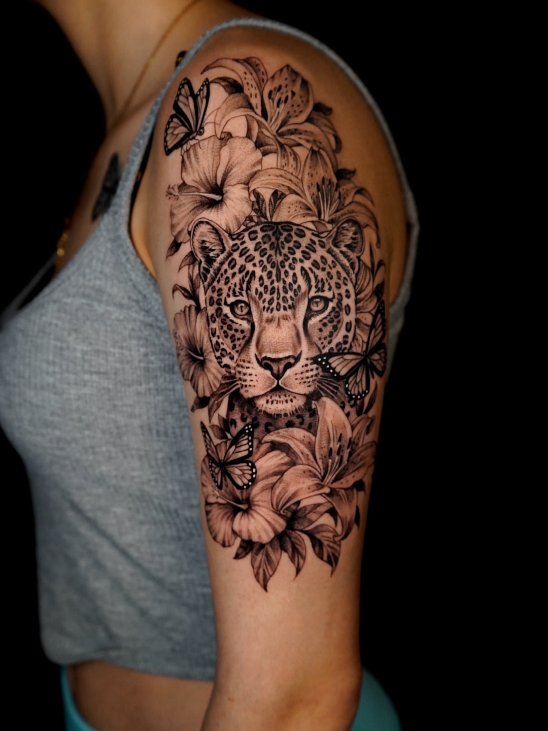 Leopard and flowers realism tattoo on the forearm by Tattoo Artist