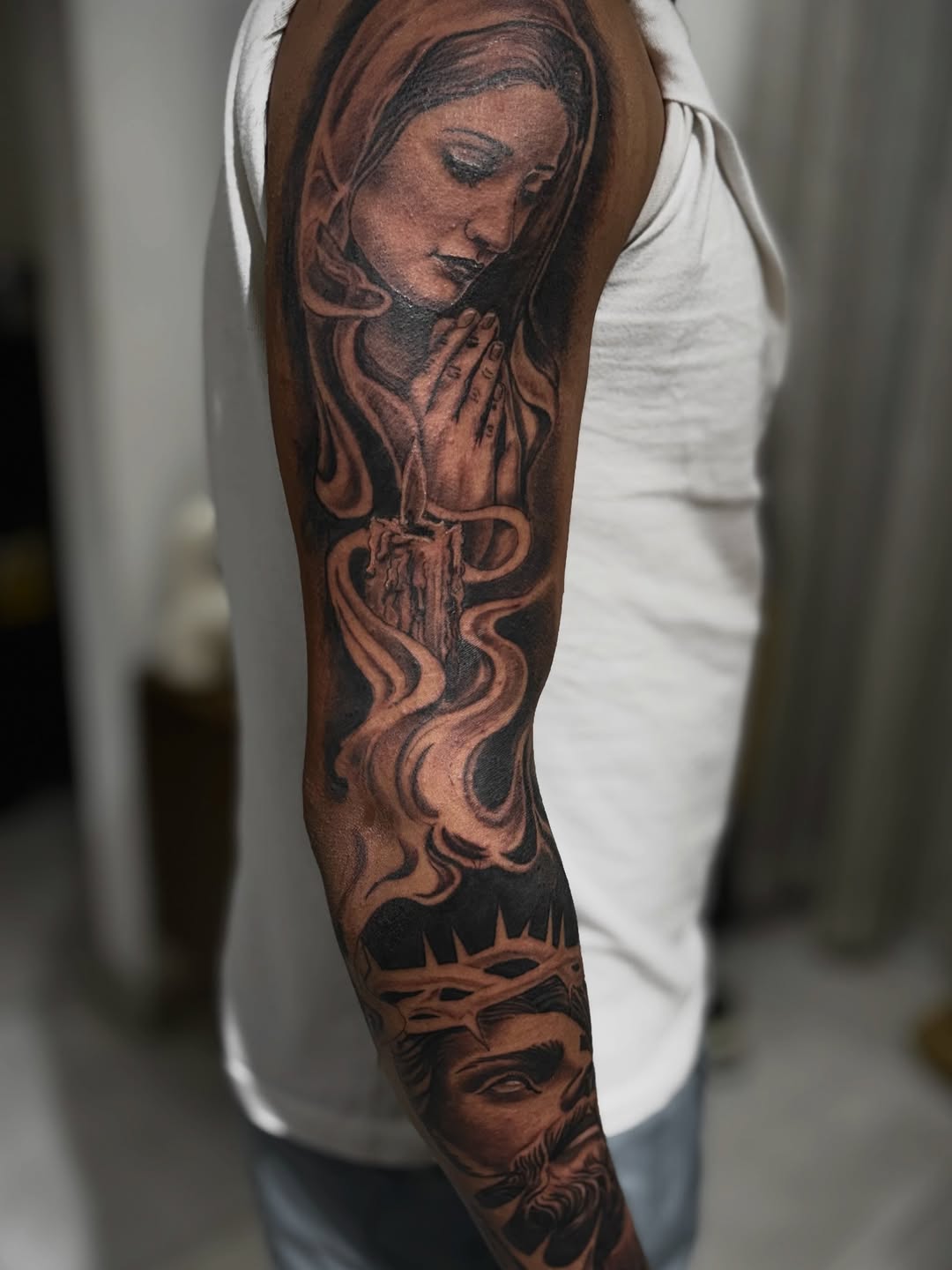 Religious figures and candle Chicano tattoo on the forearm by Mauricio gois