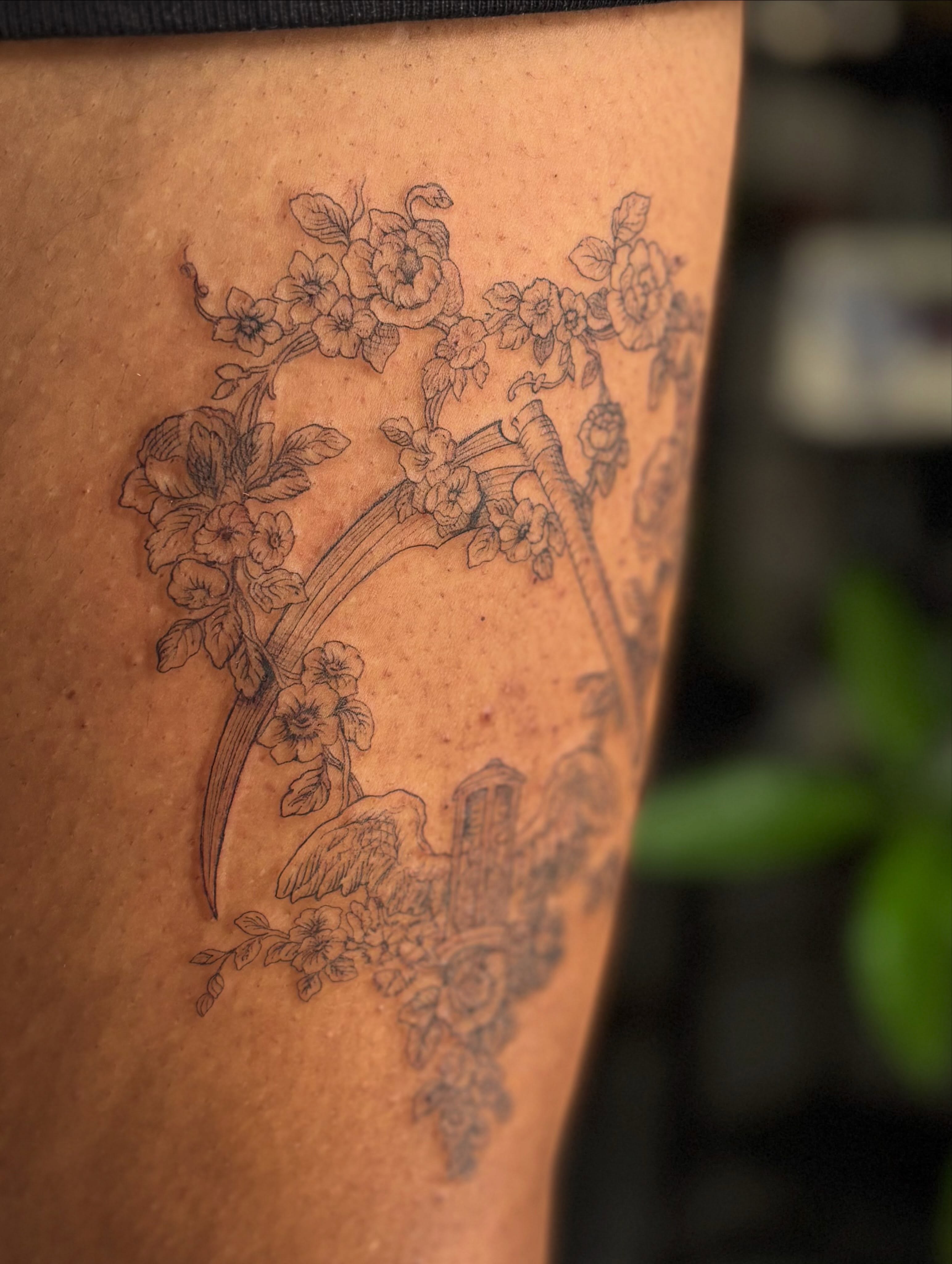 Book and floral black and grey tattoo on the thigh by Marissa Whitaker