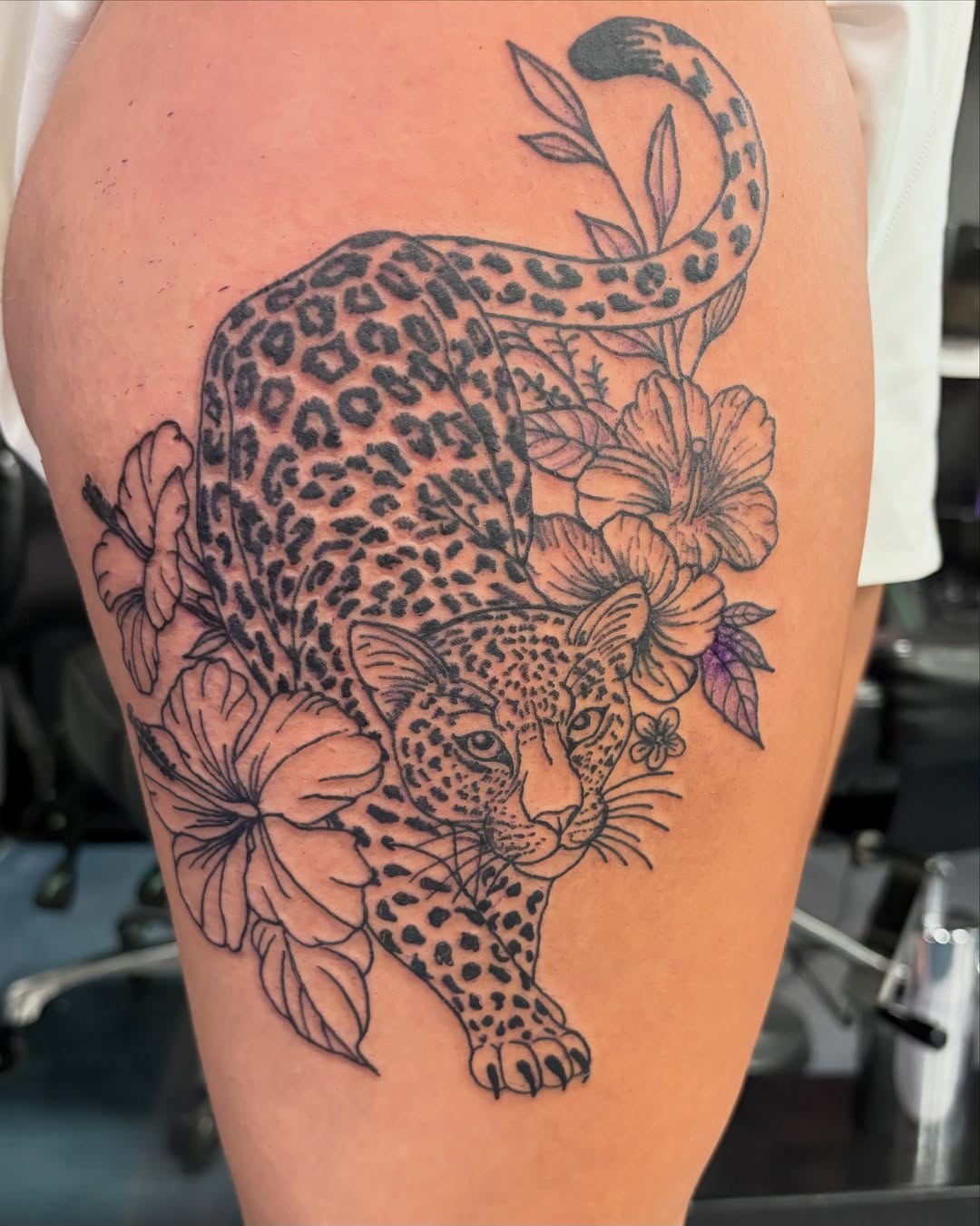 Leopard with flowers realism tattoo on the thigh by Tori Anderson, Minneapolis, Minnesota