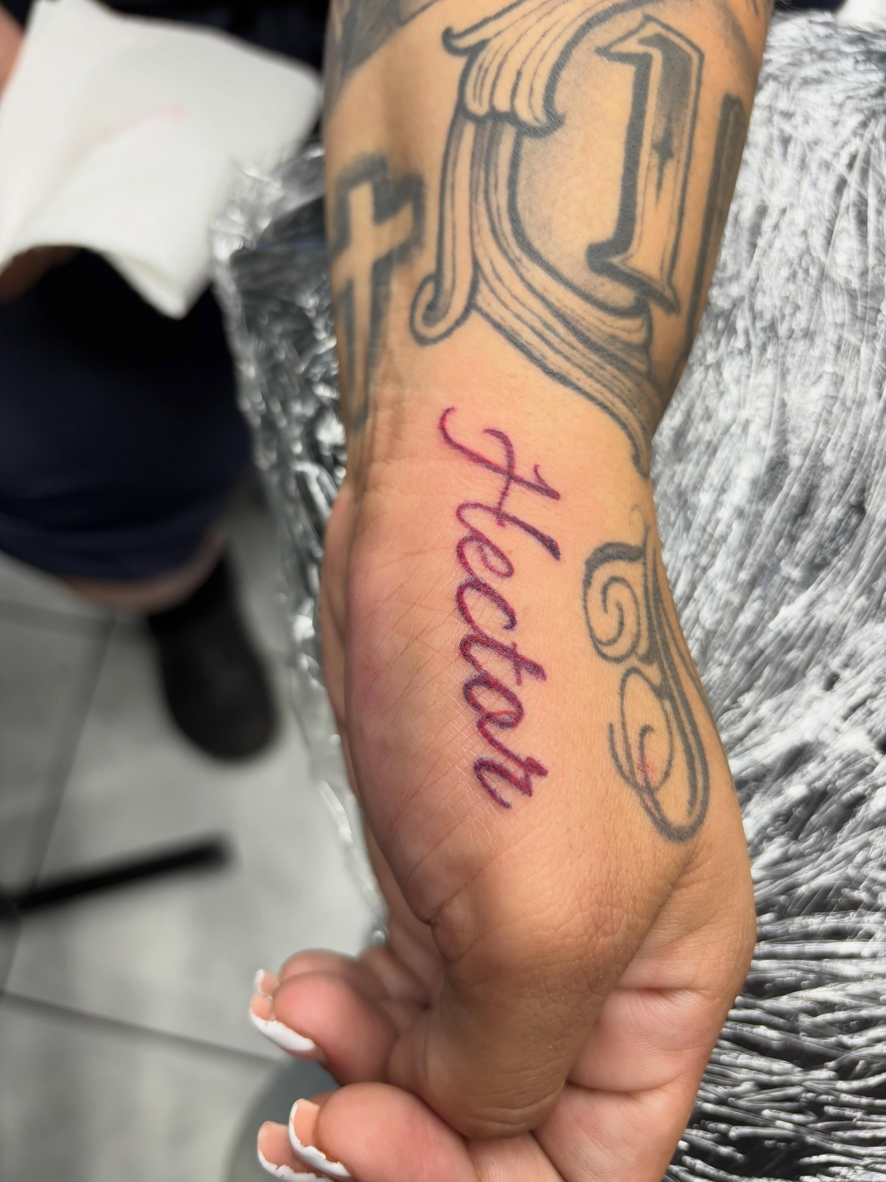 Hector lettering script tattoo on the forearm by Shadows Tattoos