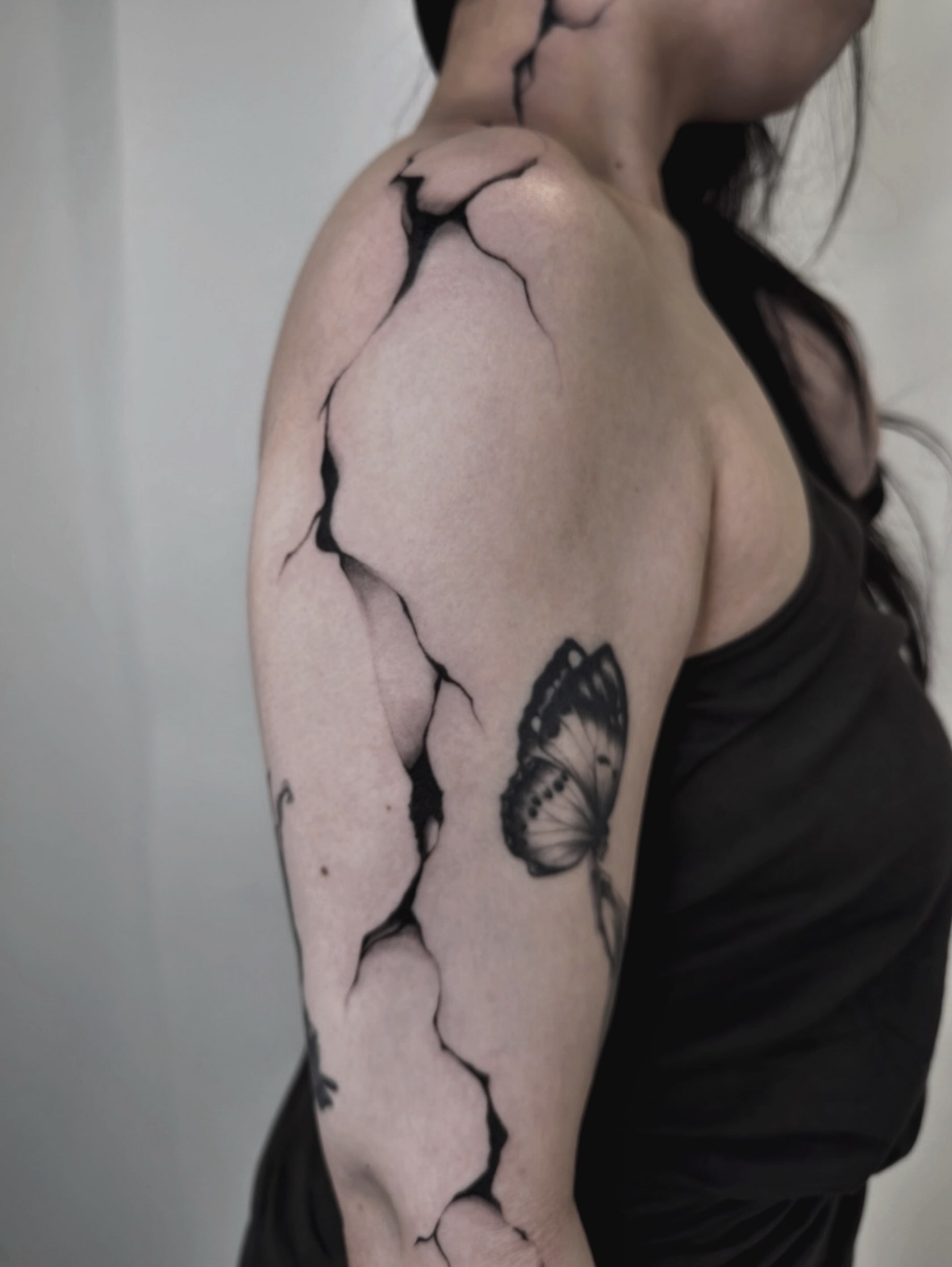 Butterfly black and grey tattoo on the upper arm by Kaelyn