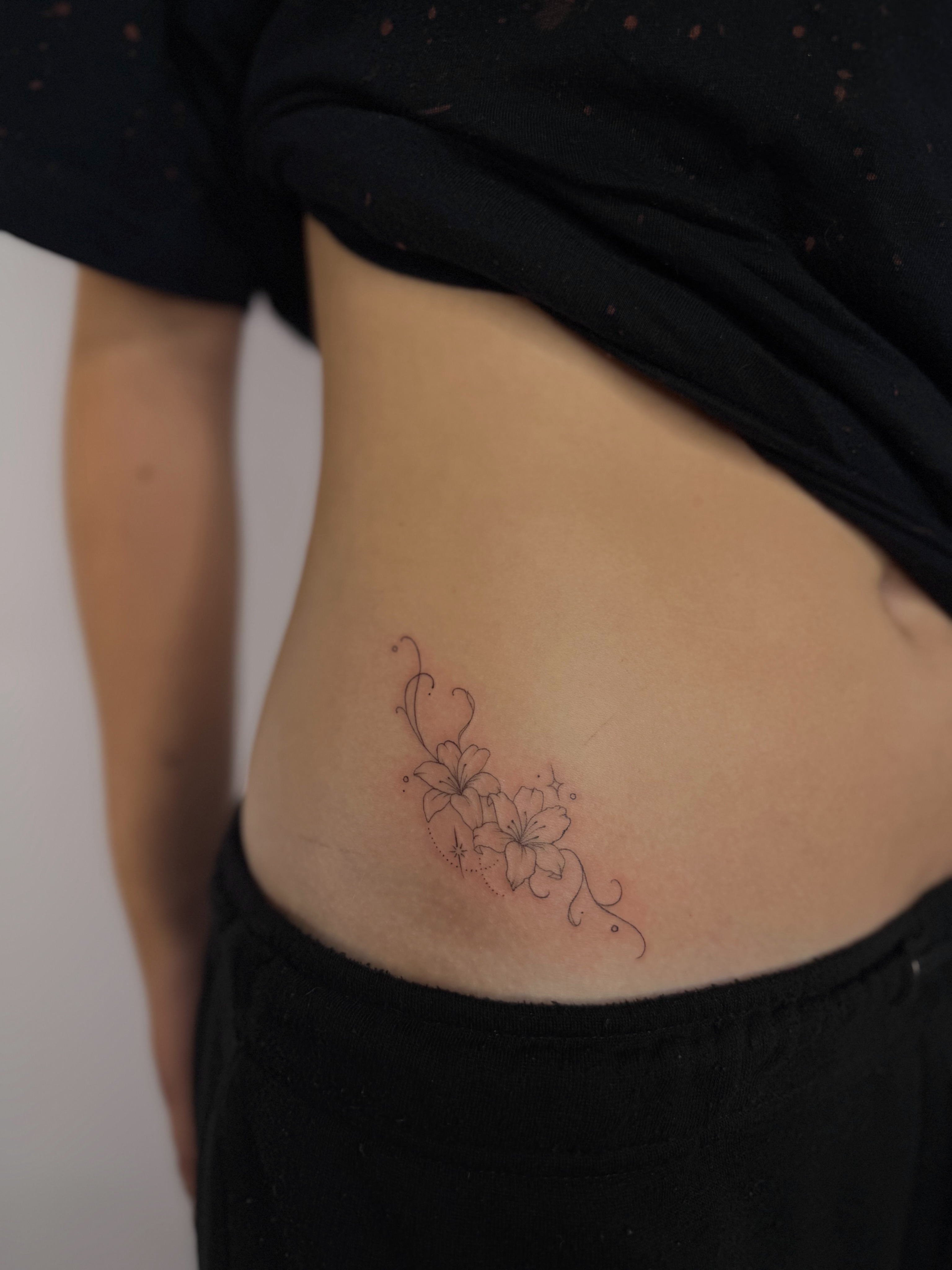 Flowers black and grey tattoo on the ribs by Fineline Tattoos DFW