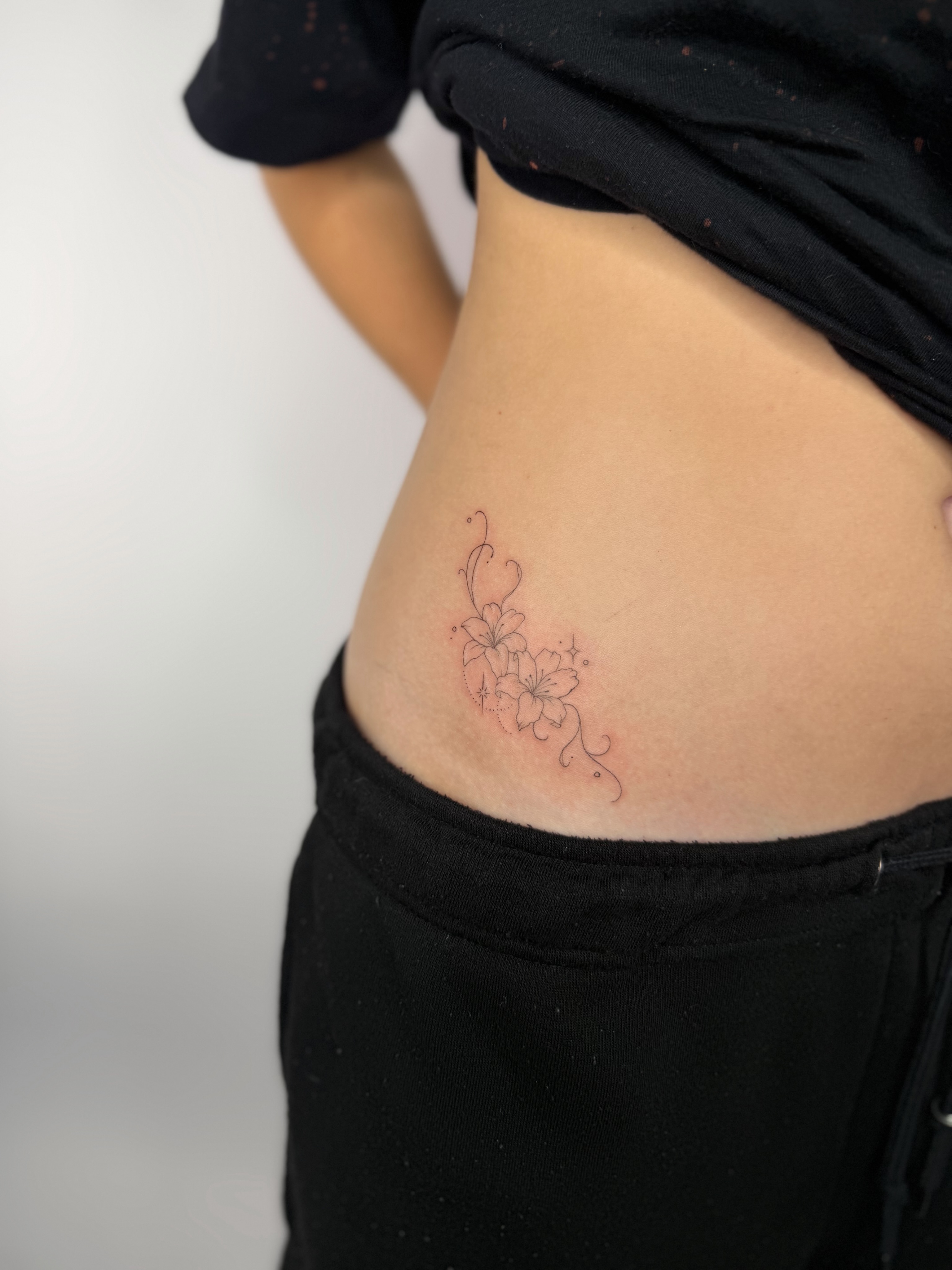 Flowers fine line tattoo on the torso by Fineline Tattoos DFW