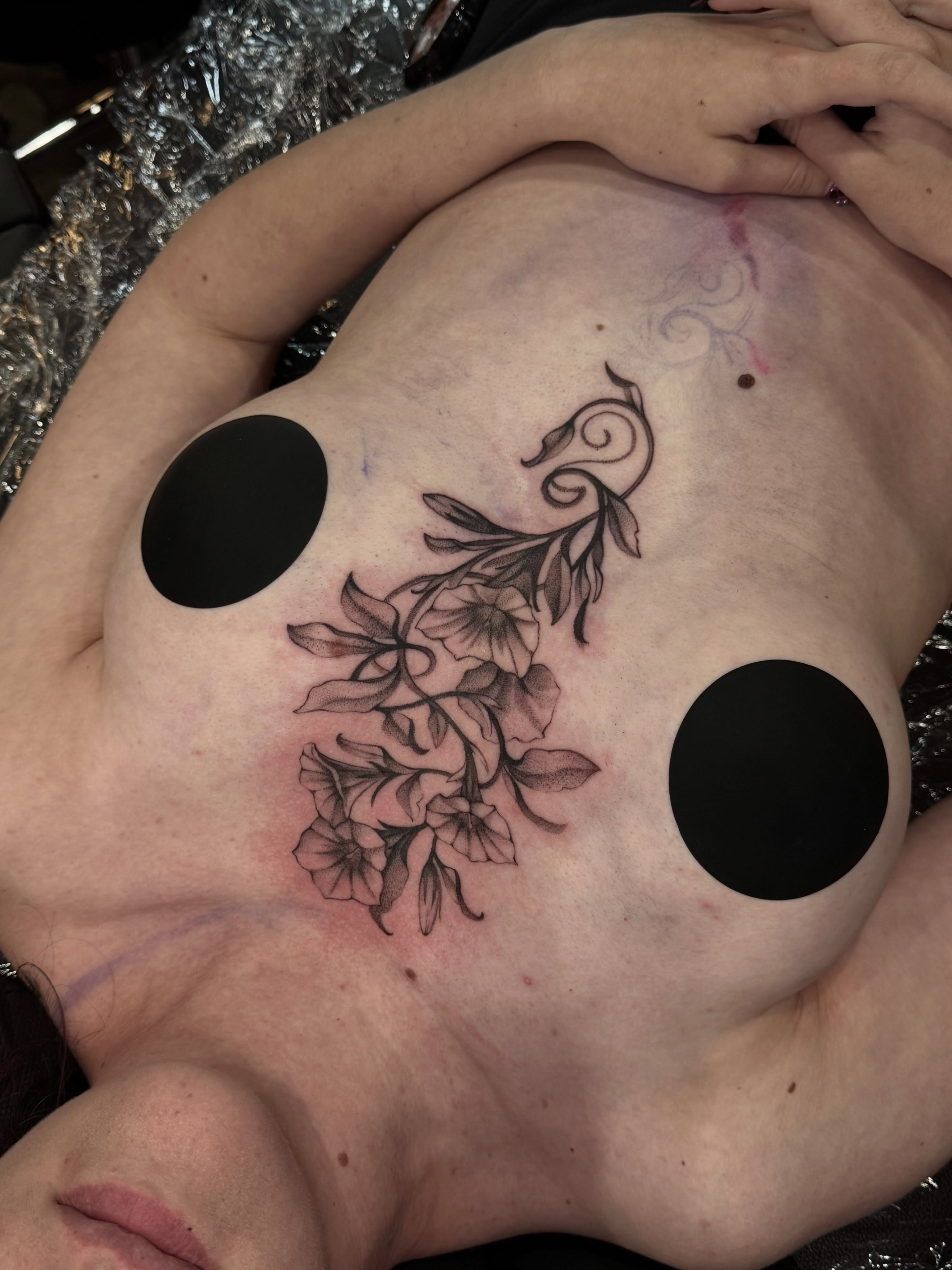 Floral bouquet black and grey tattoo on the chest by Marina Spell