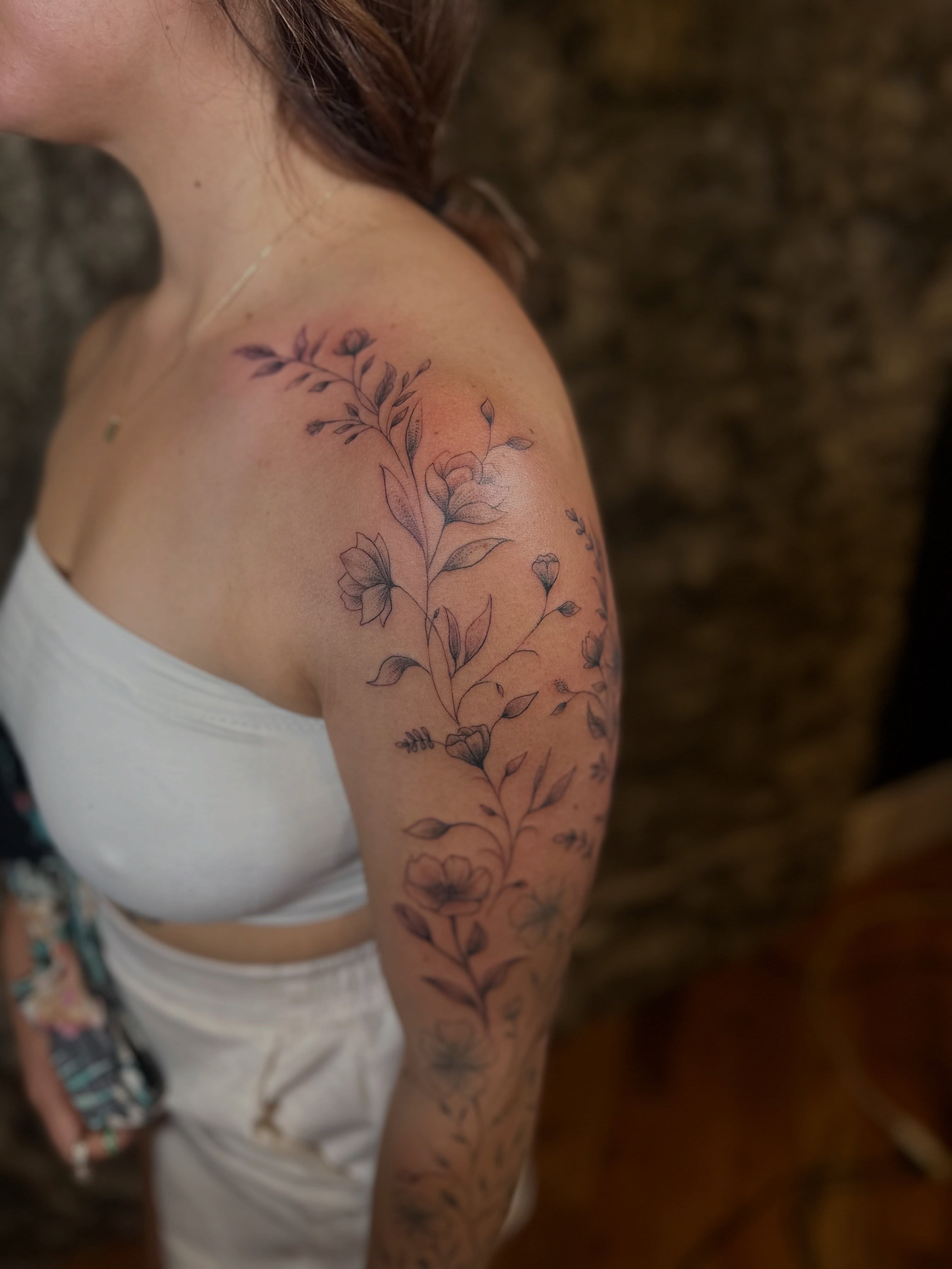 Floral arrangement black and grey tattoo on the shoulder by Ric Castellon Tattoo Artist, Los Angeles, California