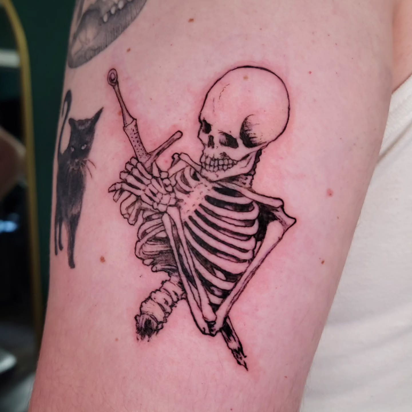 Skeleton with cat black and grey tattoo on the forearm by Nathan Harkins-Oberbeck