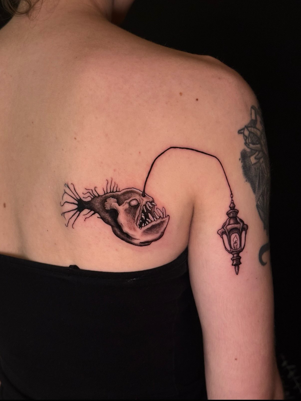 Angler fish black and grey tattoo on the back by marlena borscheid