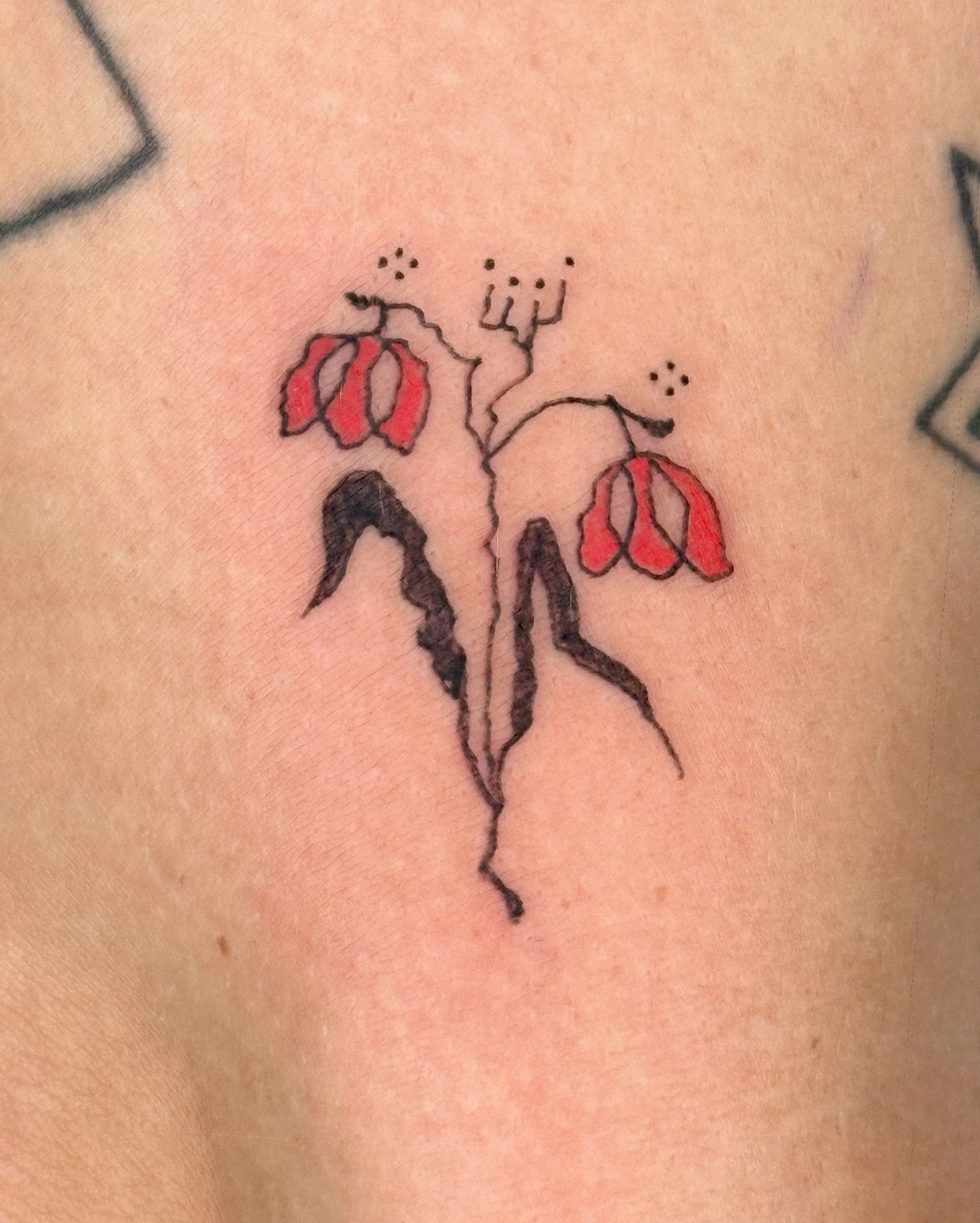 Abstract floral dotwork tattoo on the upper arm by Eden Kalif