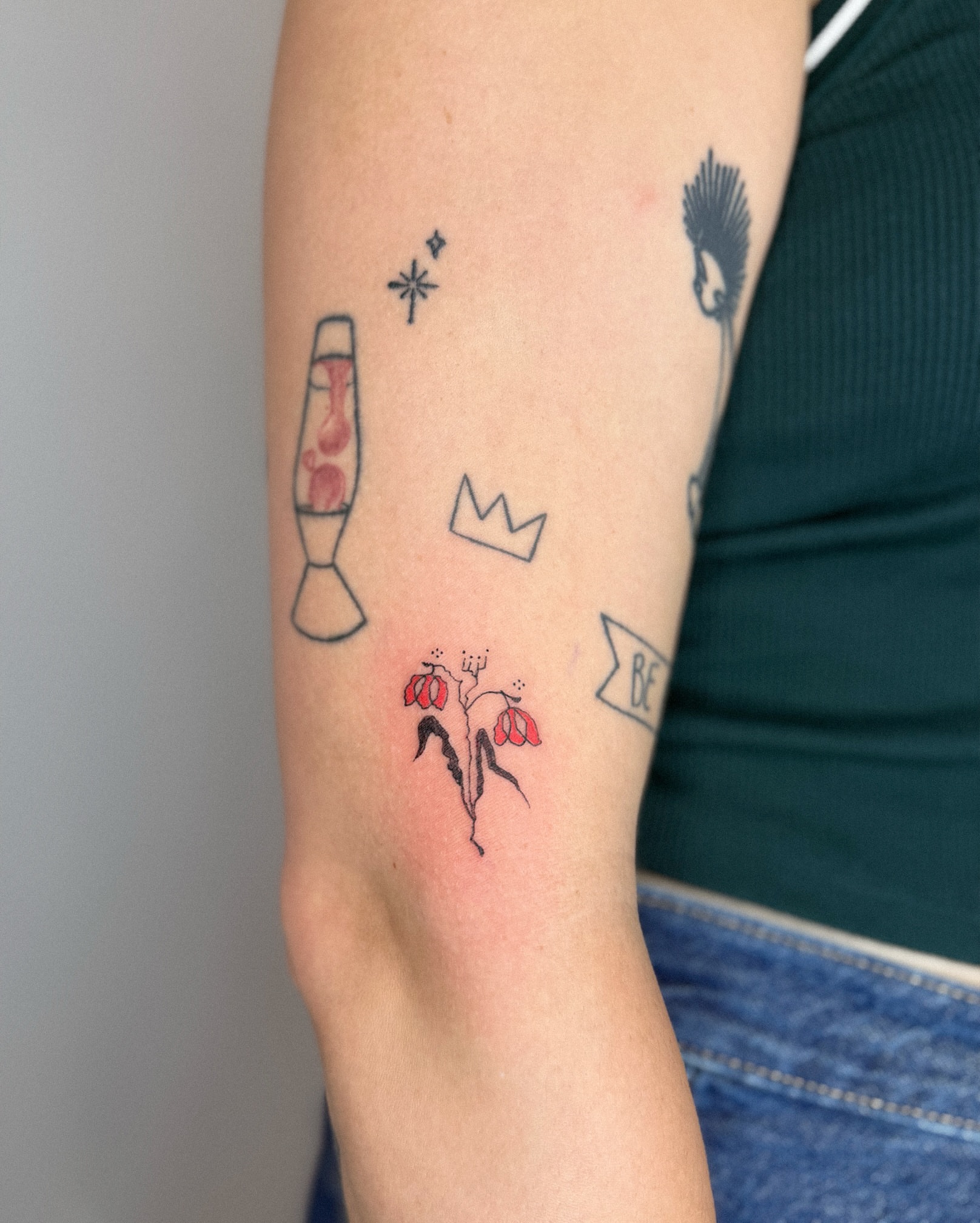 Lava lamp, crown, flowers, banner minimalist tattoo on the forearm by Eden Kalif